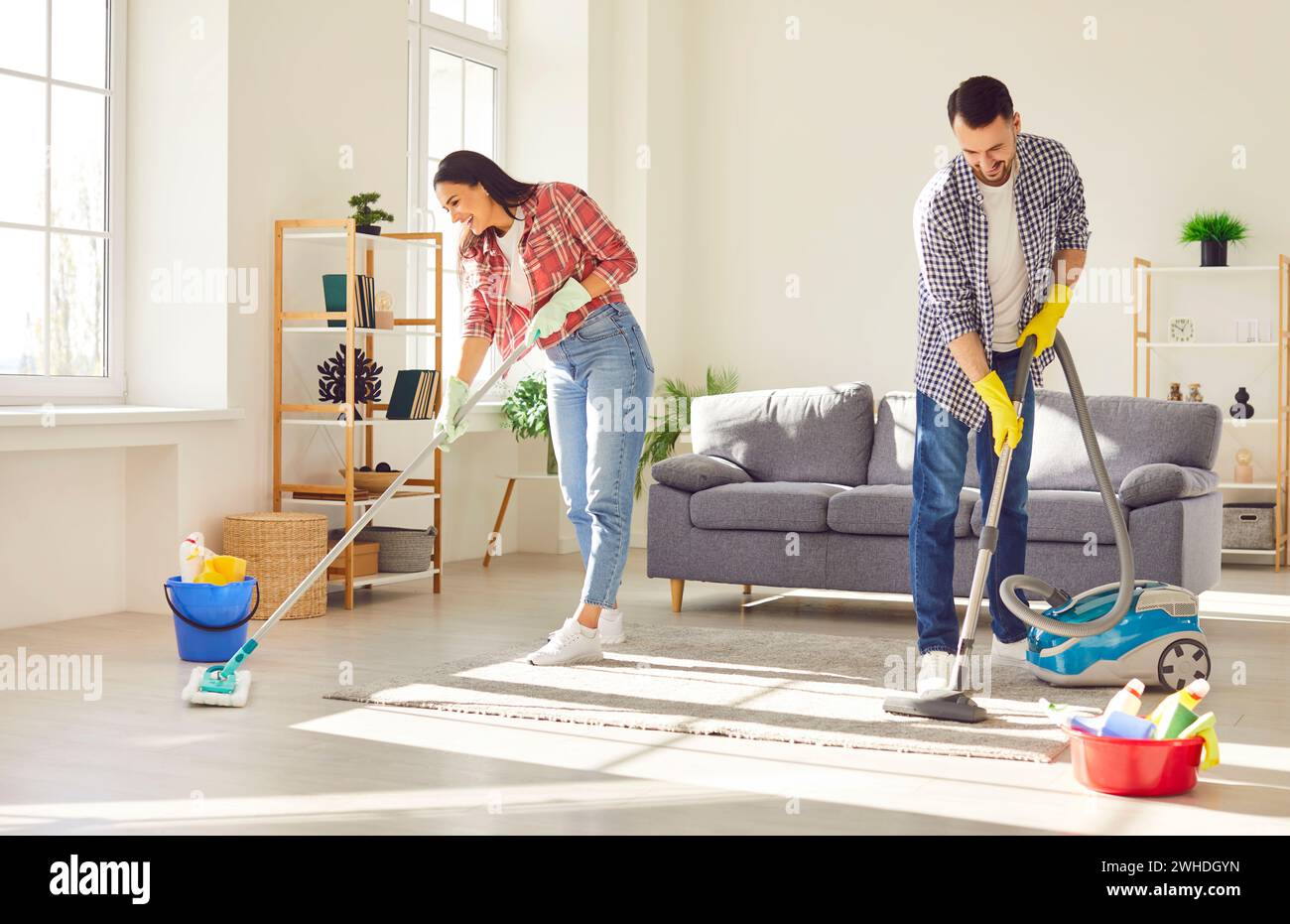 Accoppiare l'aspirapolvere e la casa per la pulizia dei panni nel soggiorno di casa. Foto Stock