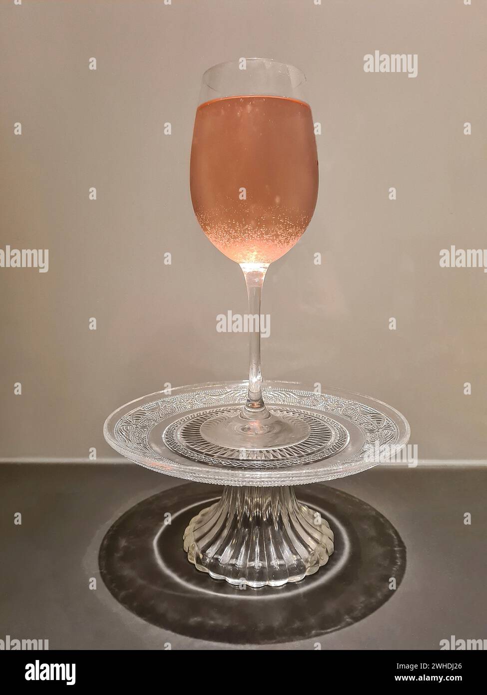 Bevanda estiva alcolica color rosa con vino frizzante o champagne in un bicchiere di vino Foto Stock