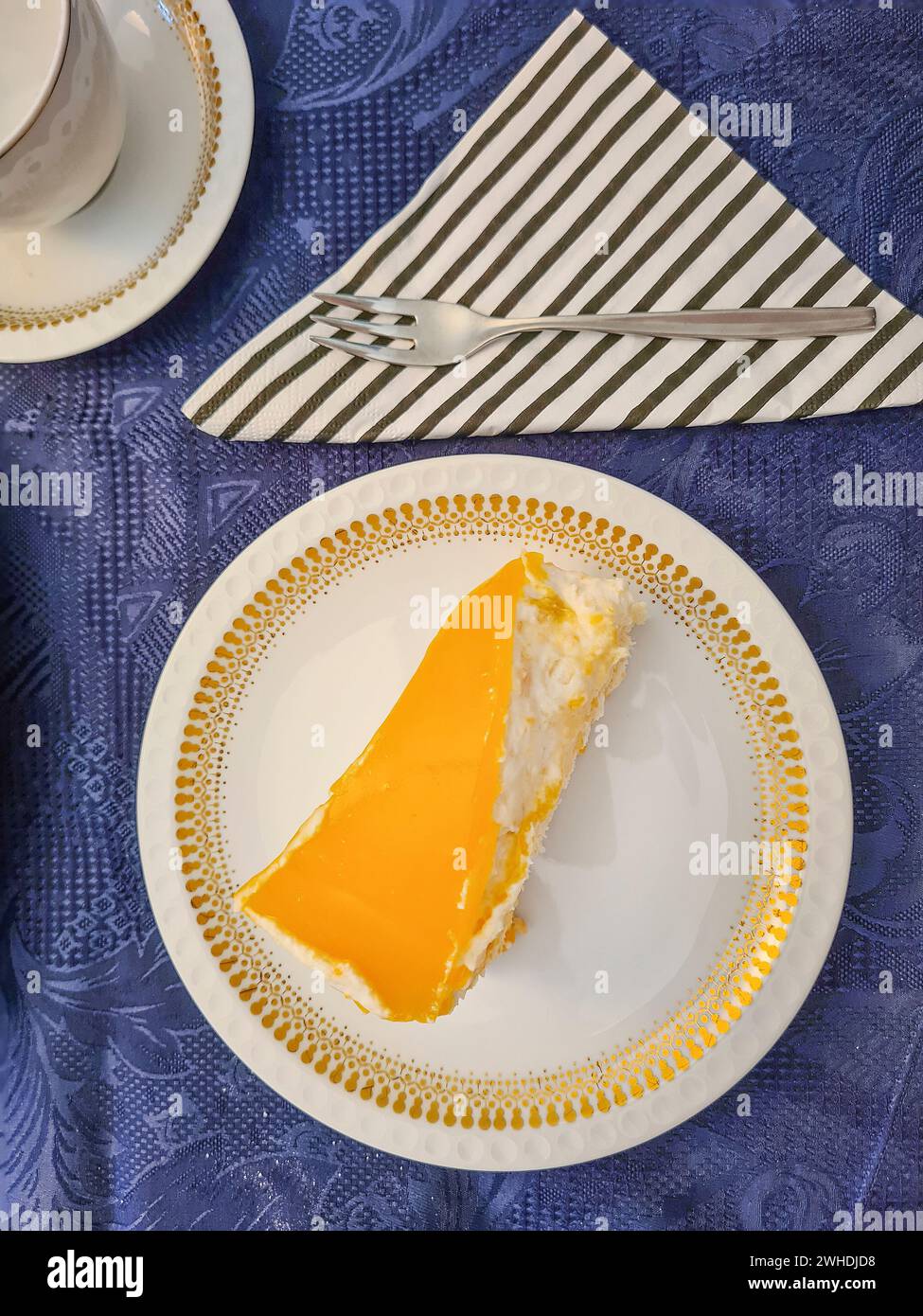Primo piano di una fetta di torta di albicocche su una tovaglia festosa blu Foto Stock