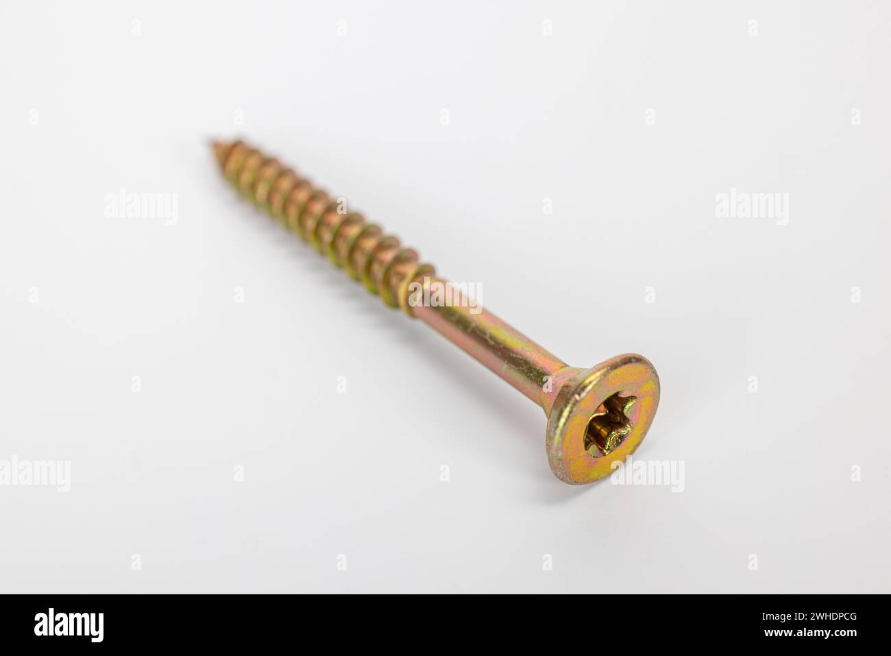 Vite truciolare Torx singola con testa svasata, zincata gialla, sfocata, fondo bianco, Foto Stock