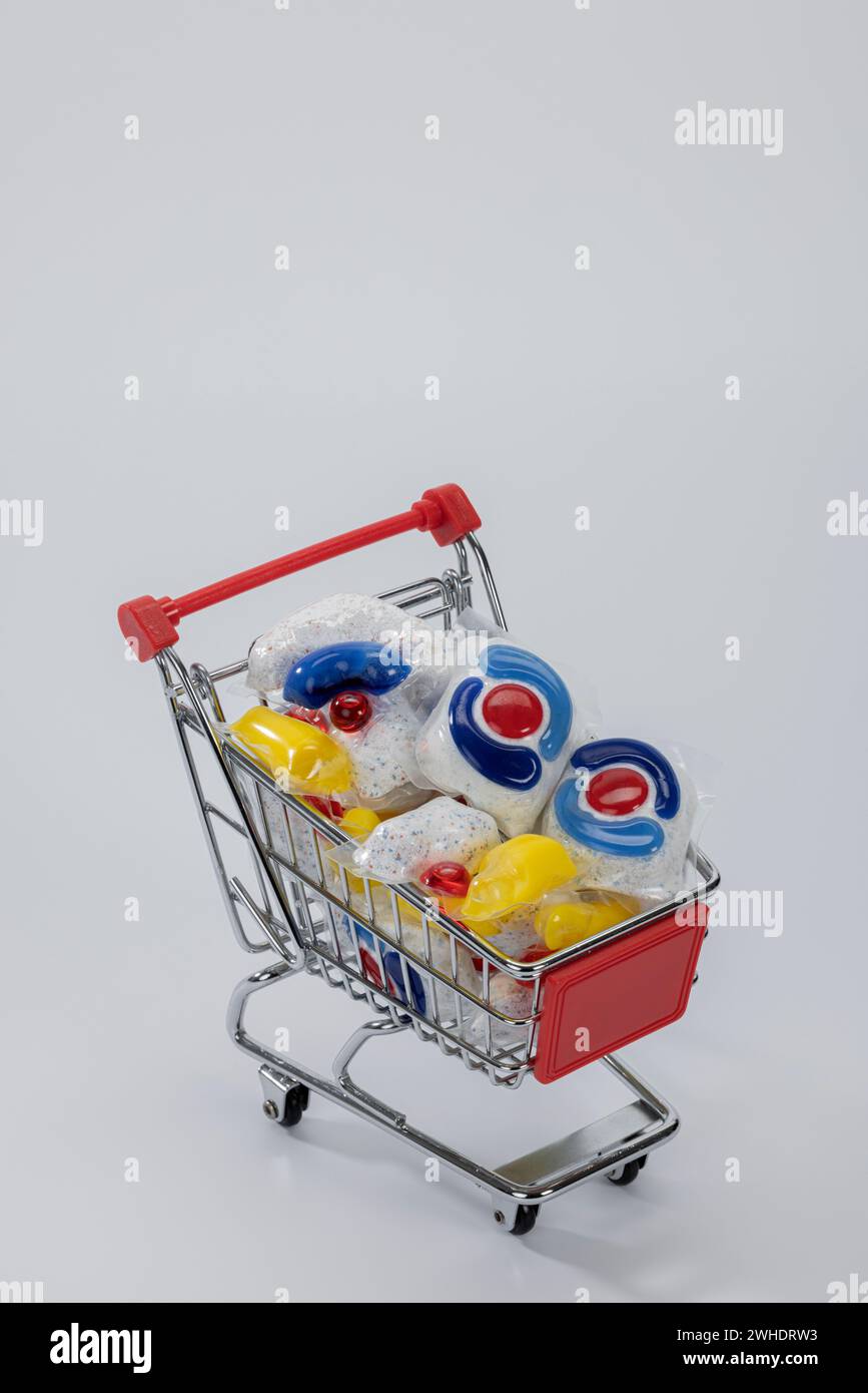 Carrello riempito con linguette lavastoviglie in foglio solubile in acqua, colorato, di varie marche, sfondo bianco, Foto Stock