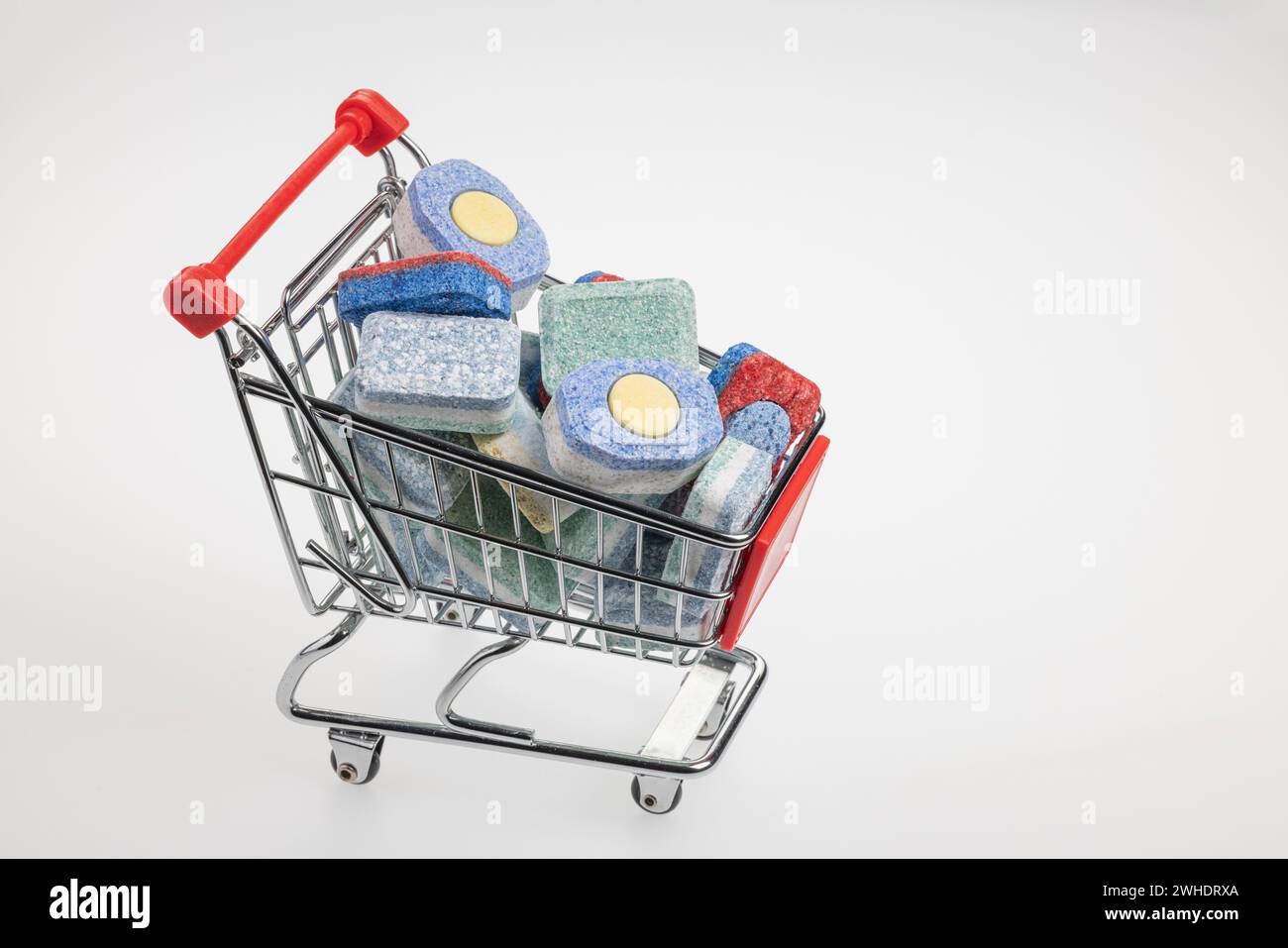 Carrello riempito con linguette lavastoviglie, vari marchi, sfondo bianco, Foto Stock