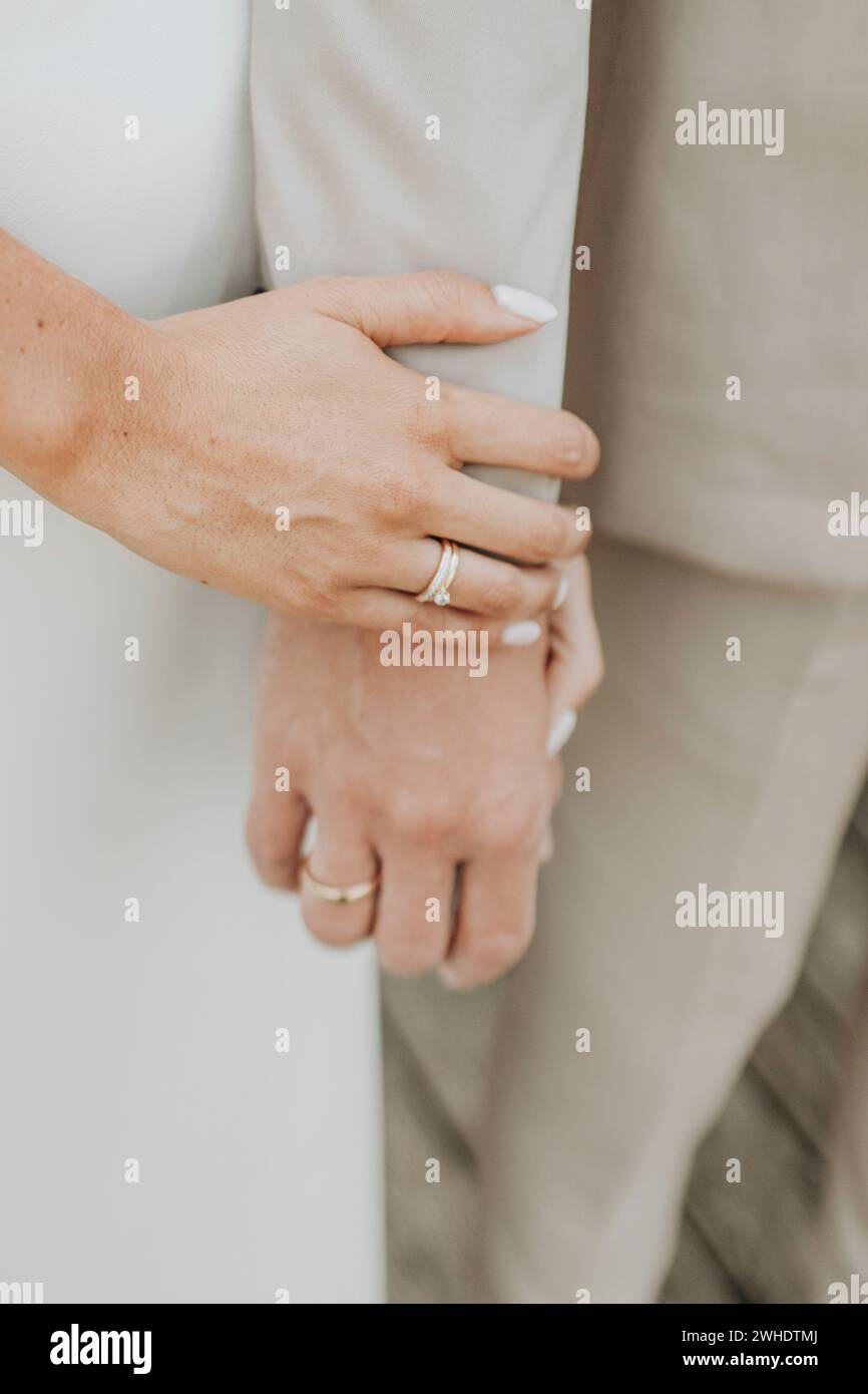 Coppia che si tiene per mano, primo piano, dettaglio, concentrazione sugli anelli Foto Stock