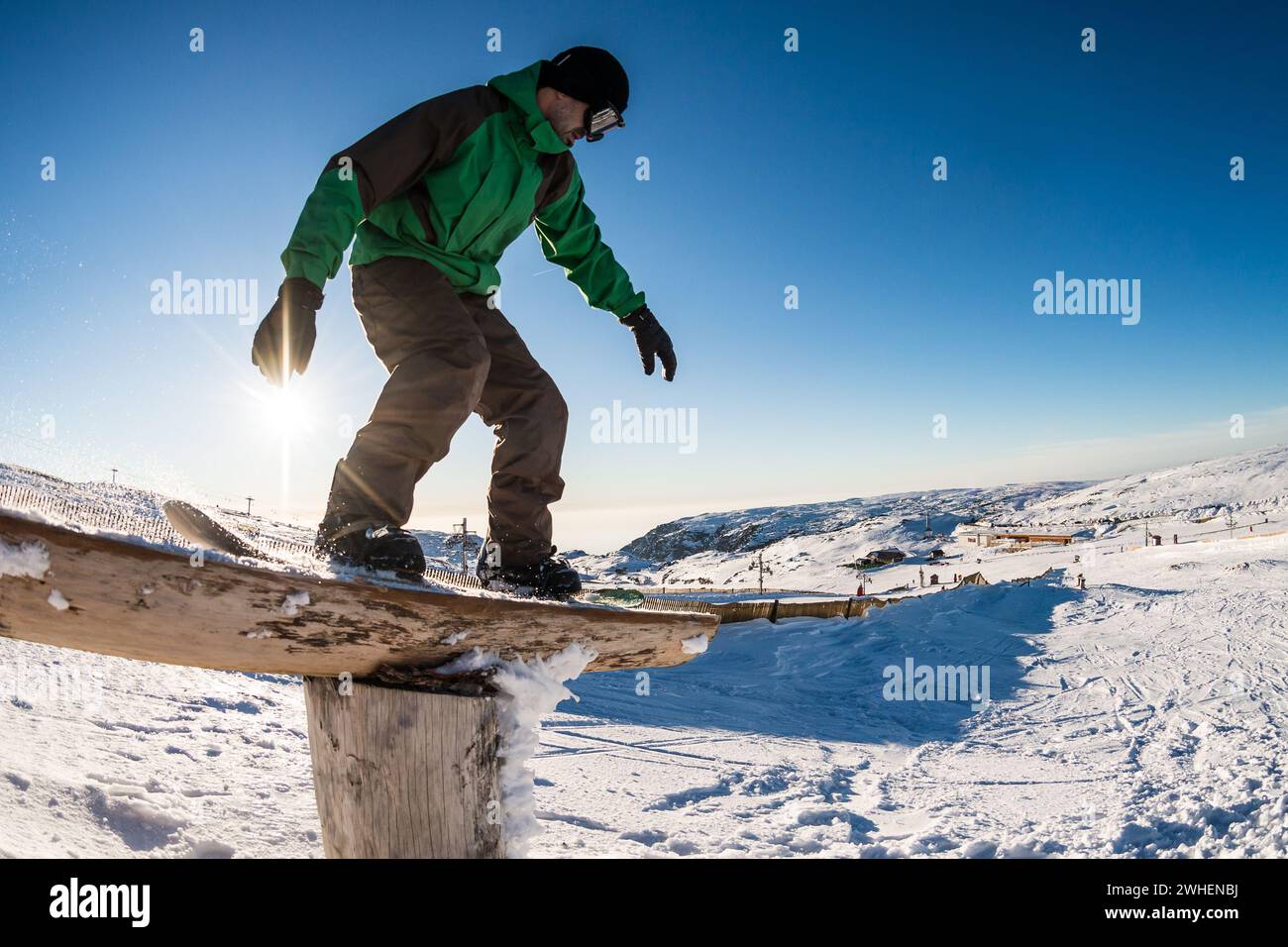 Snowboarder che scivola su una rotaia Foto Stock