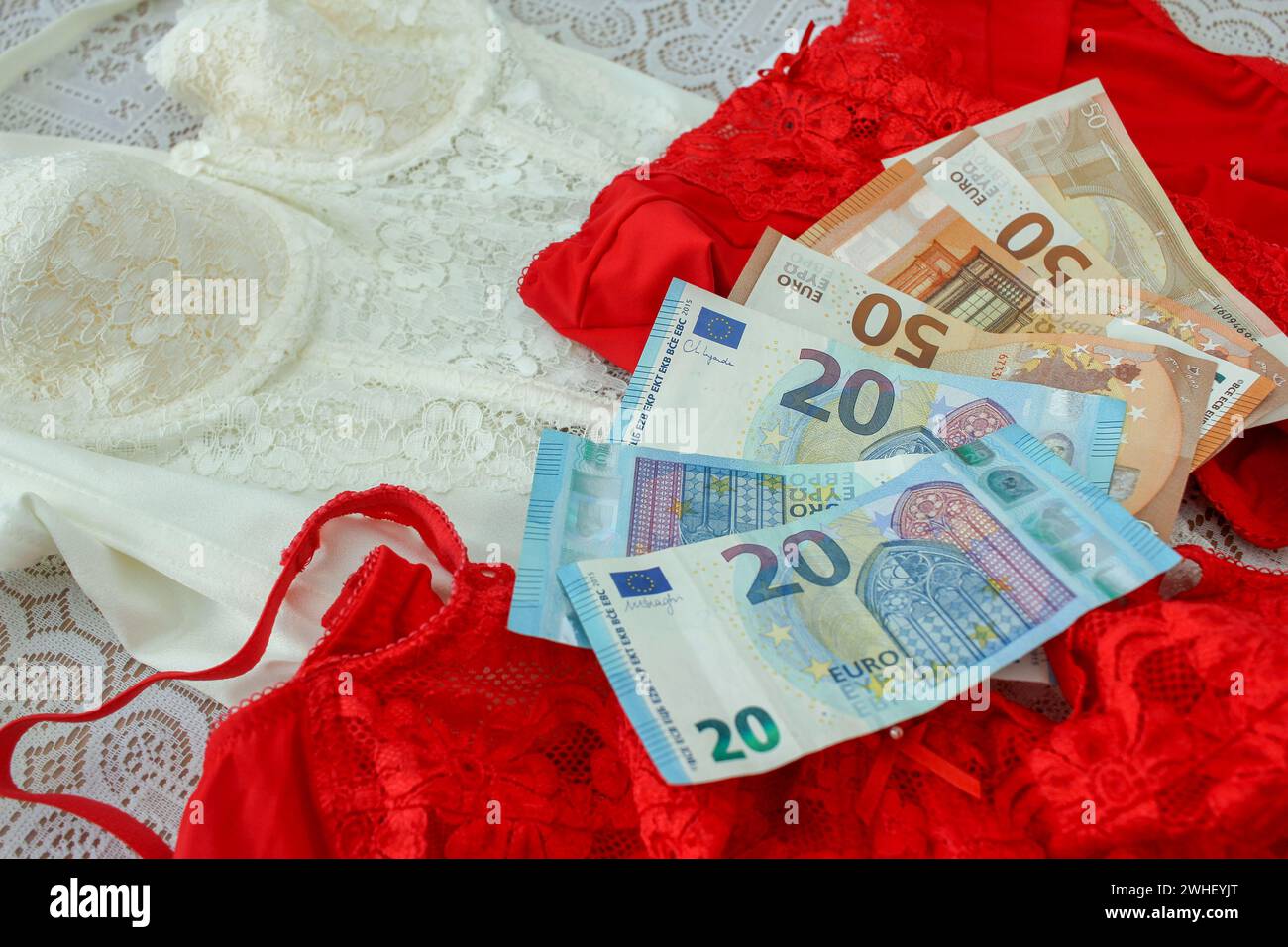 Gli indumenti rossi e gli euro rappresentano la componente monetaria del giorno di San Valentino, raffigurando le spese per regali romantici Foto Stock