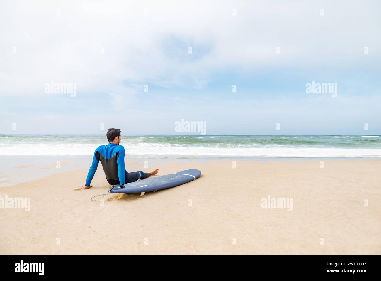 Giovane surfista che indossa la muta Foto Stock