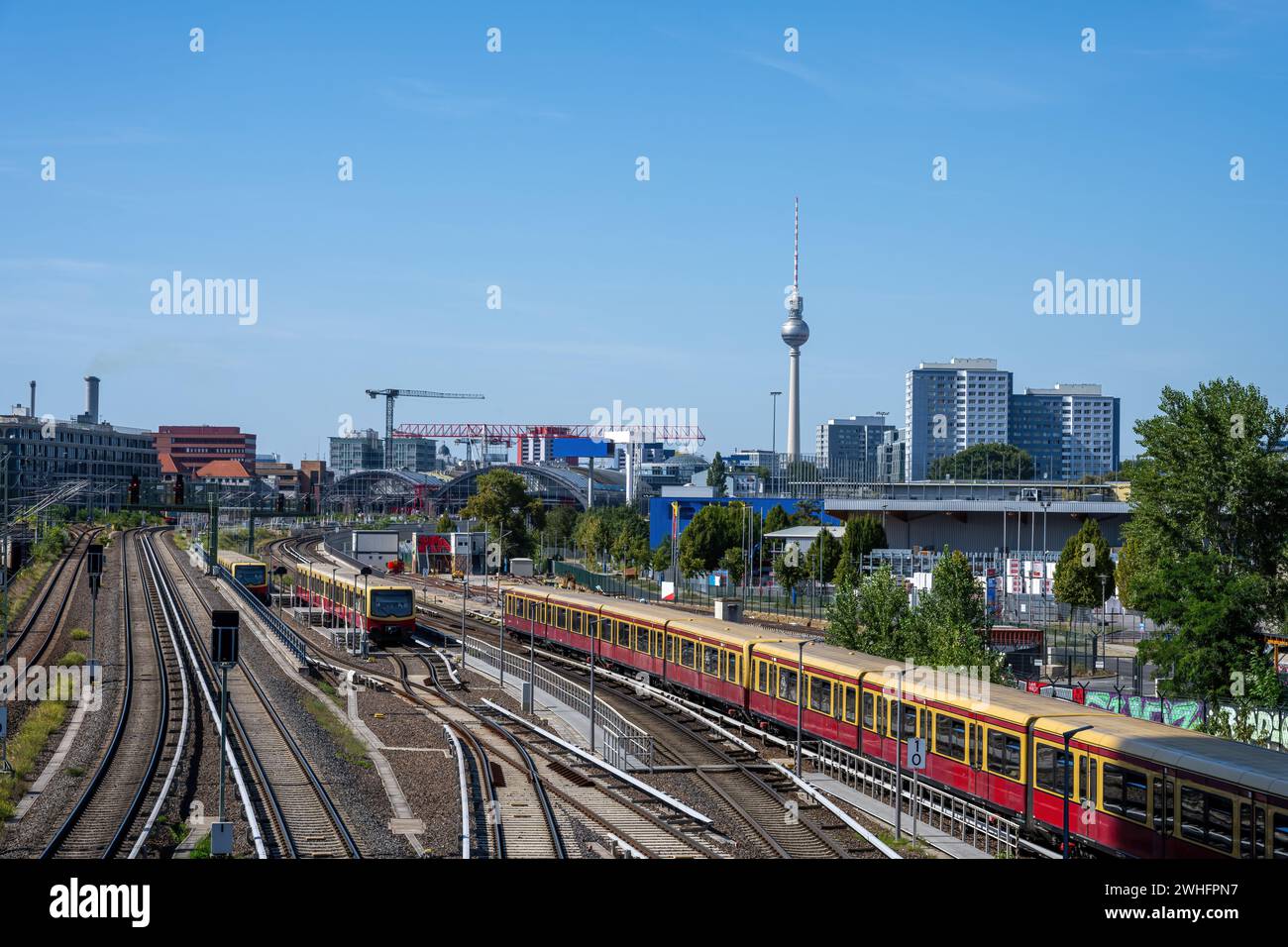 Treni locali per pendolari a Berlino, in Germania, con la famosa torre della televisione sul retro Foto Stock