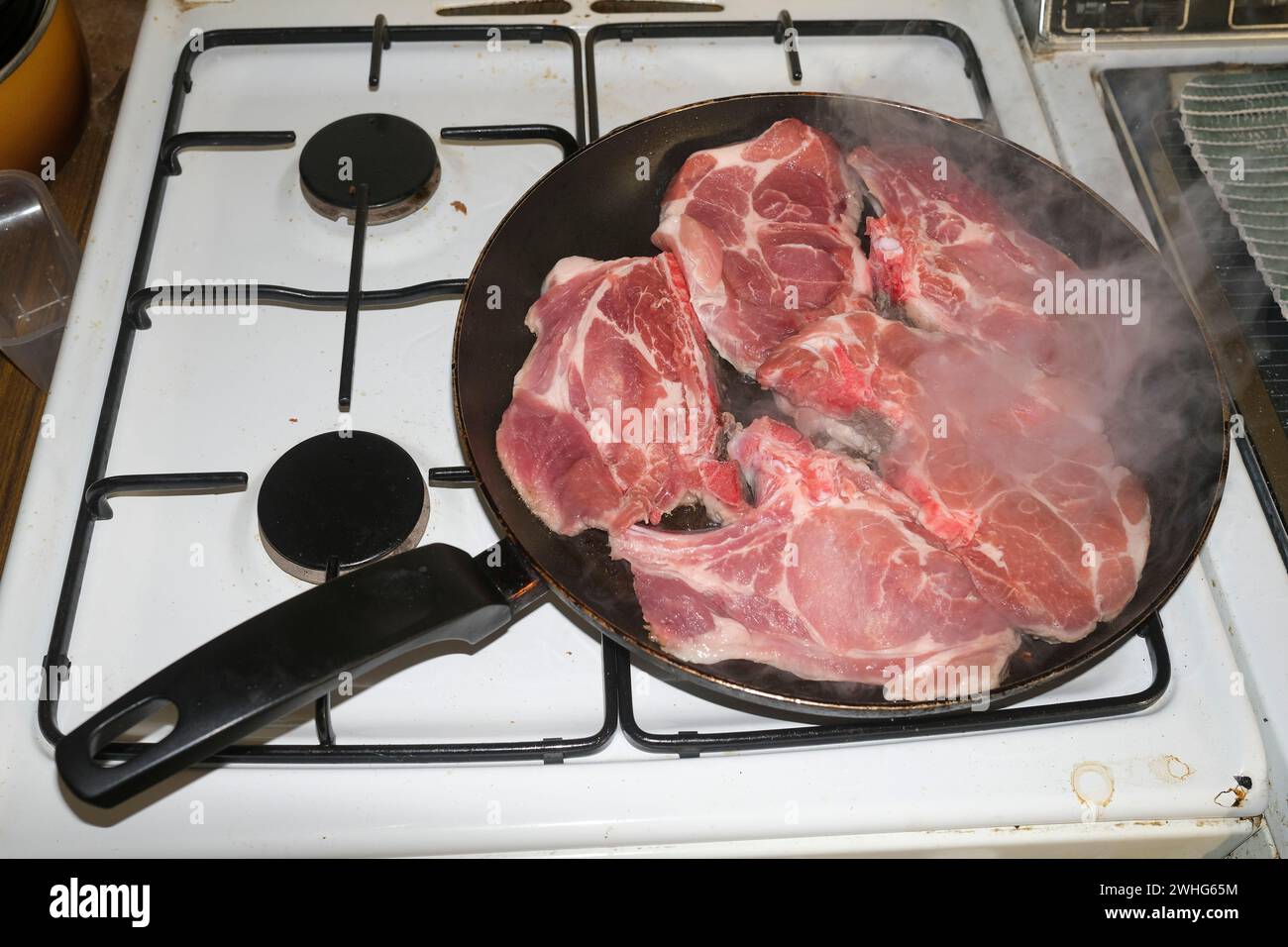 cuocere la carne di maiale trita la carne in una padella Foto Stock