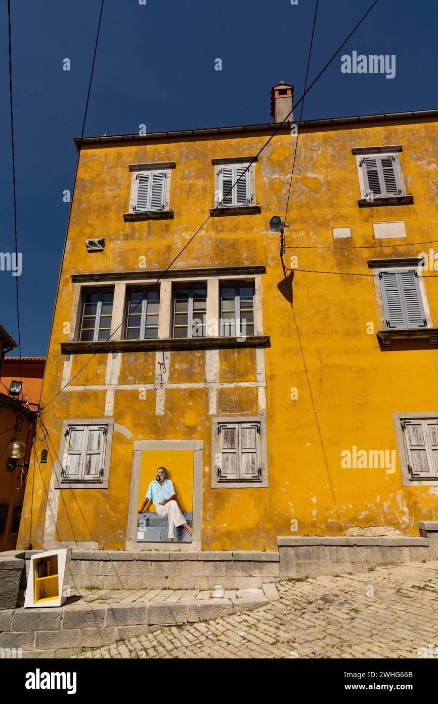 Edificio giallo con pitture murali in Croazia Foto Stock