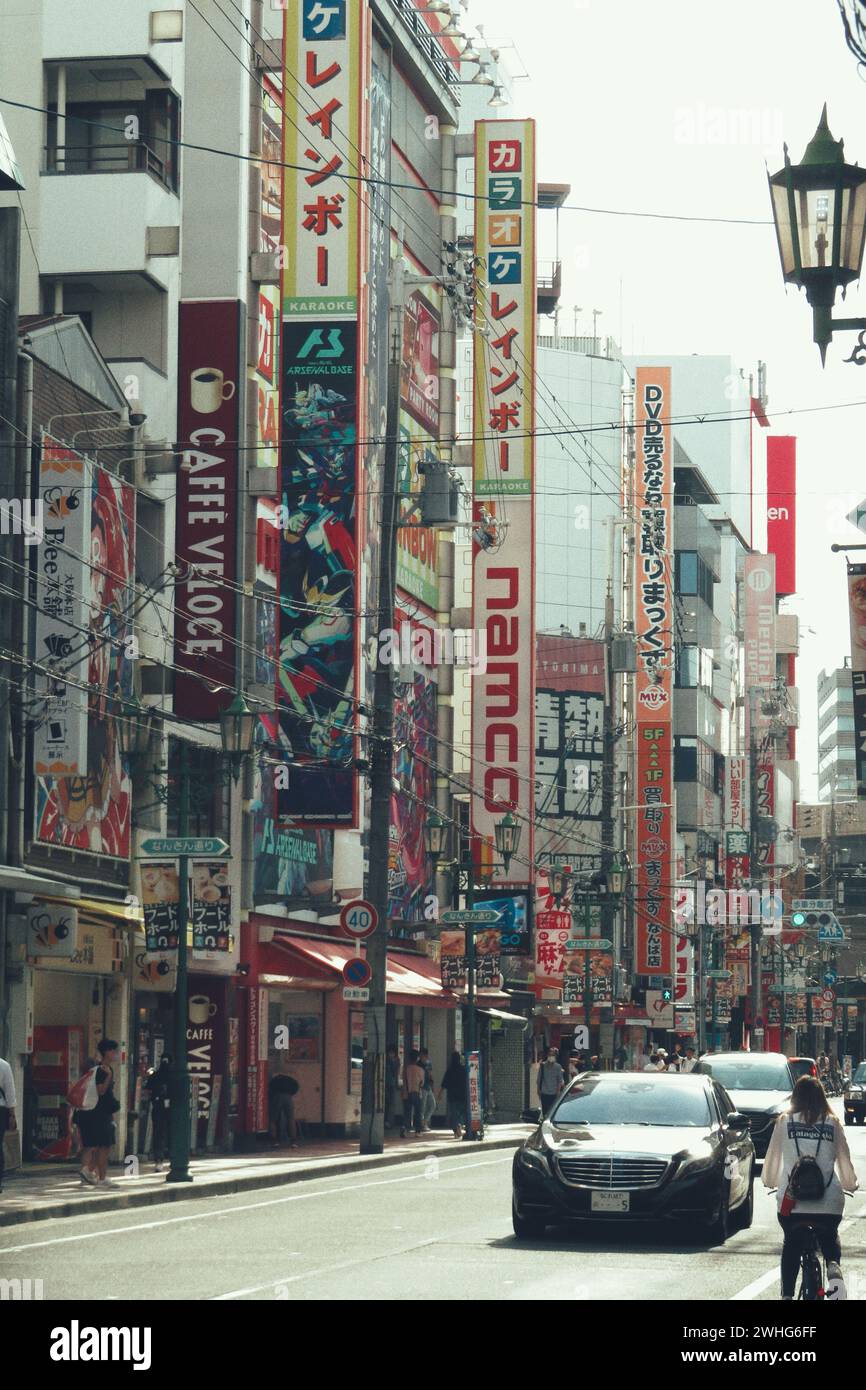 Una vivace scena urbana di strada con veicoli, pedoni e attività movimentate a Osaka, Giappone. Foto Stock