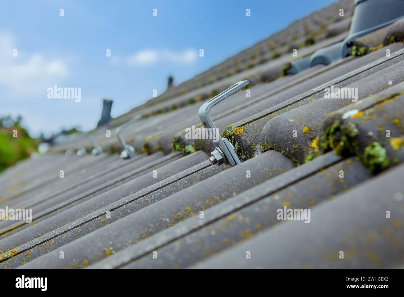 Gancio di montaggio fotovoltaico sul tetto. Preparazione per l'installazione di pannelli solari. guida di montaggio Foto Stock