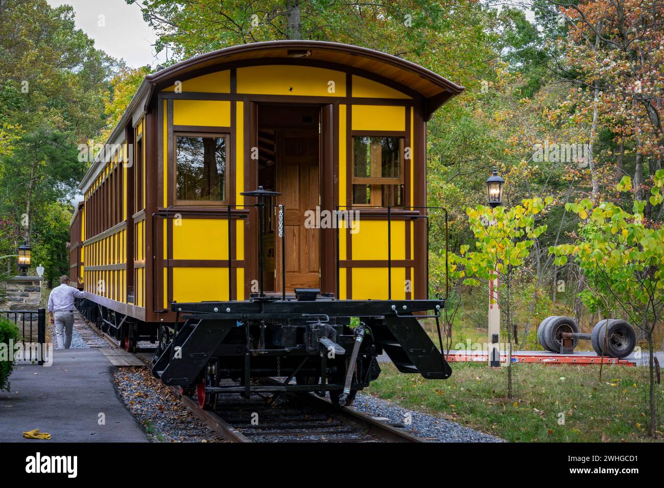 Installazione di un nuovo pullman d'antiquariato giallo per passeggeri sollevato da una gru Foto Stock