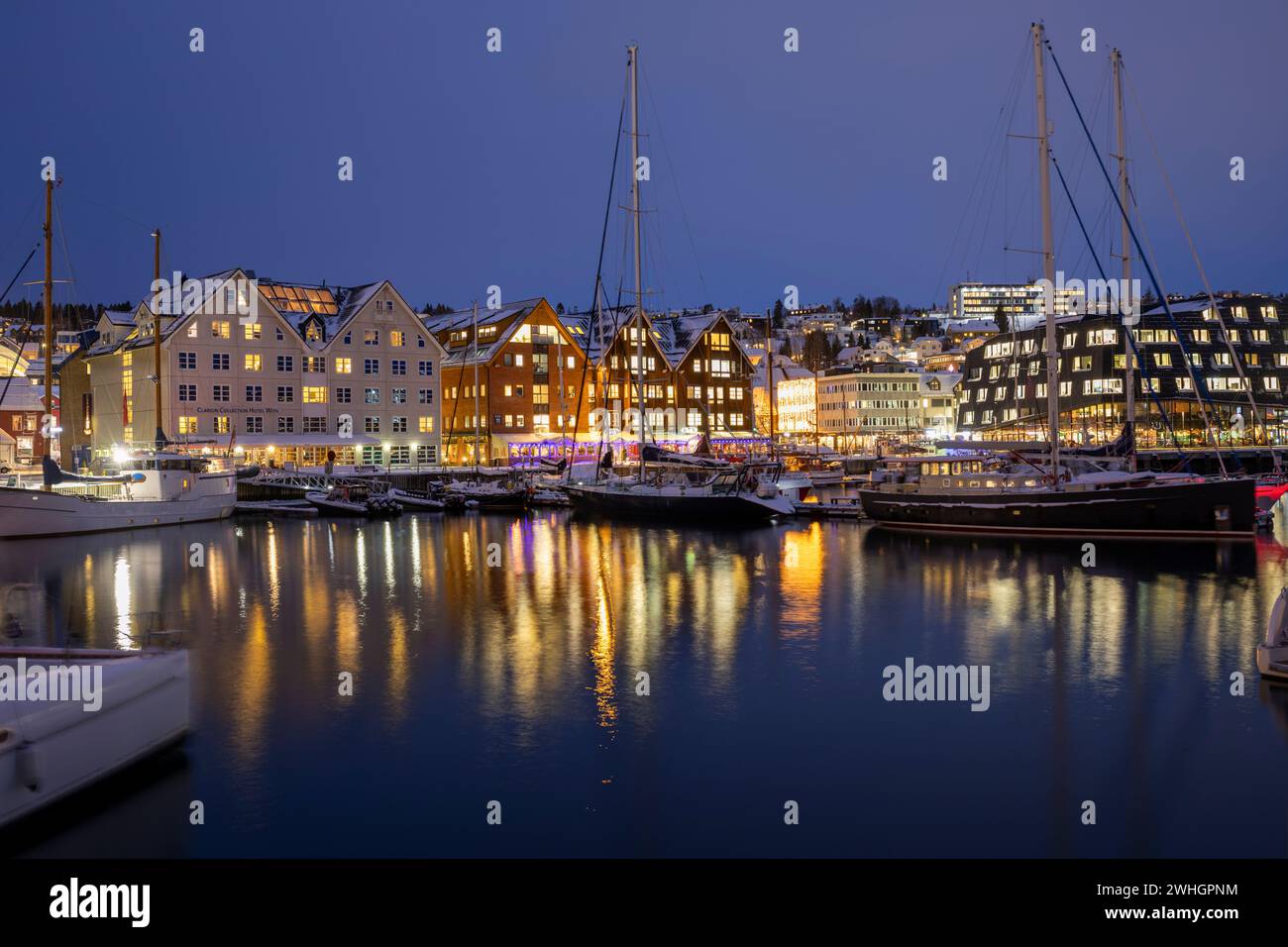 Europa, Norvegia, porto di Tromso di notte con barche ormeggiate in inverno Foto Stock