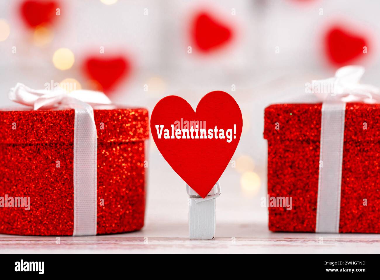10 febbraio 2024: San Valentino scrivendo su un cuore rosso accanto ai regali FOTOMONTAGGIO *** Valentinstag Schrift auf einem roten Herz neben Geschenken FOTOMONTAGE Foto Stock