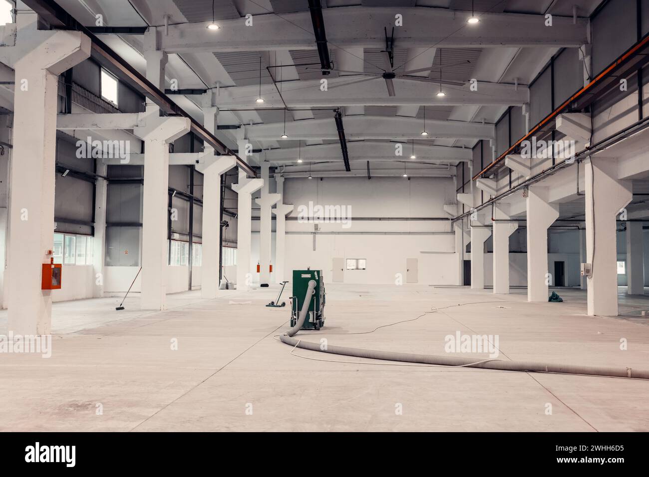 Manutenzione per un moderno magazzino industriale. Riscaldare le apparecchiature nel soffitto. Foto Stock