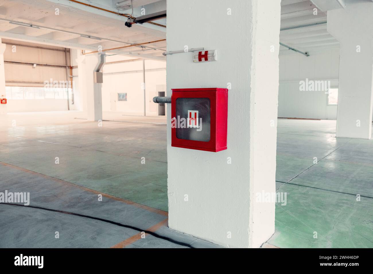 preparazione per la conflagrazione di emergenza, armadio antincendio con cartello in un edificio industriale Foto Stock