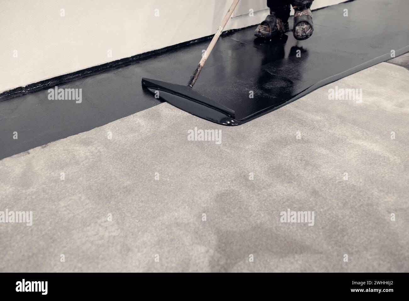 Resina epossidica nera che rende il nuovo pavimento liscio Foto Stock