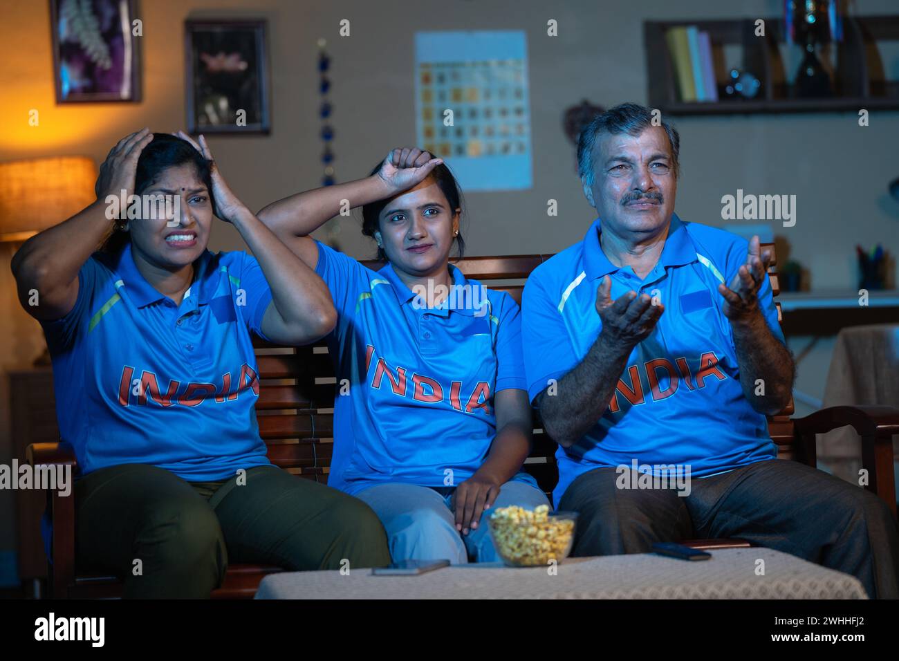 la famiglia è diventata triste a causa della perdita di partita di cricket mentre guardavano in tv o in televisione a casa - concetto di competizione, campionato e delusione Foto Stock