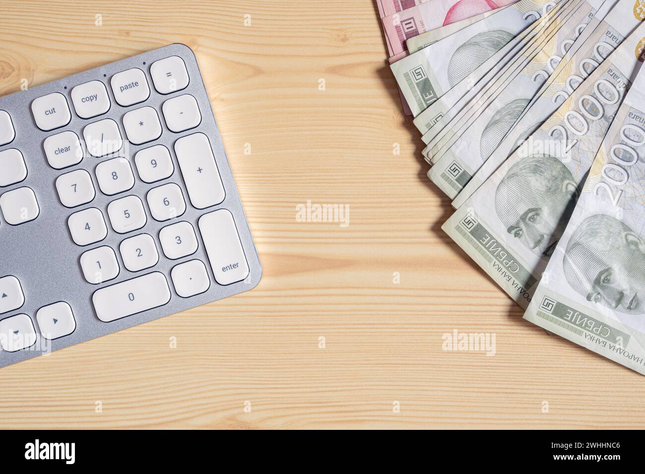 Tastiera per PC desktop e banconote serbe in valuta dinaro sulla scrivania dell'ufficio, vista dall'alto Foto Stock