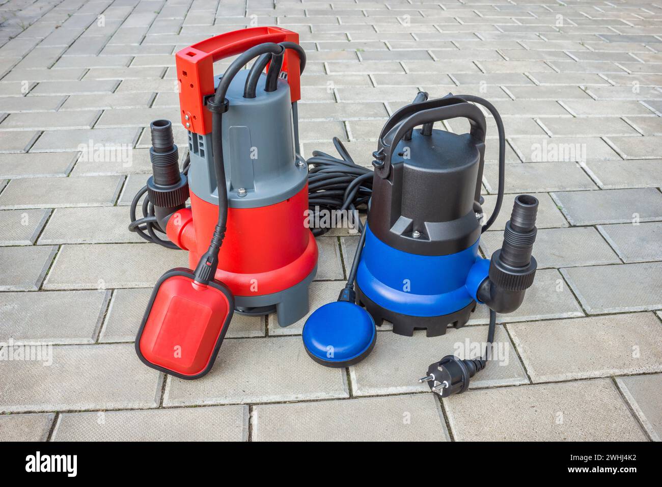 Due pompe sommergibili per uso domestico con alloggiamenti in plastica su pavimento in pietra Foto Stock