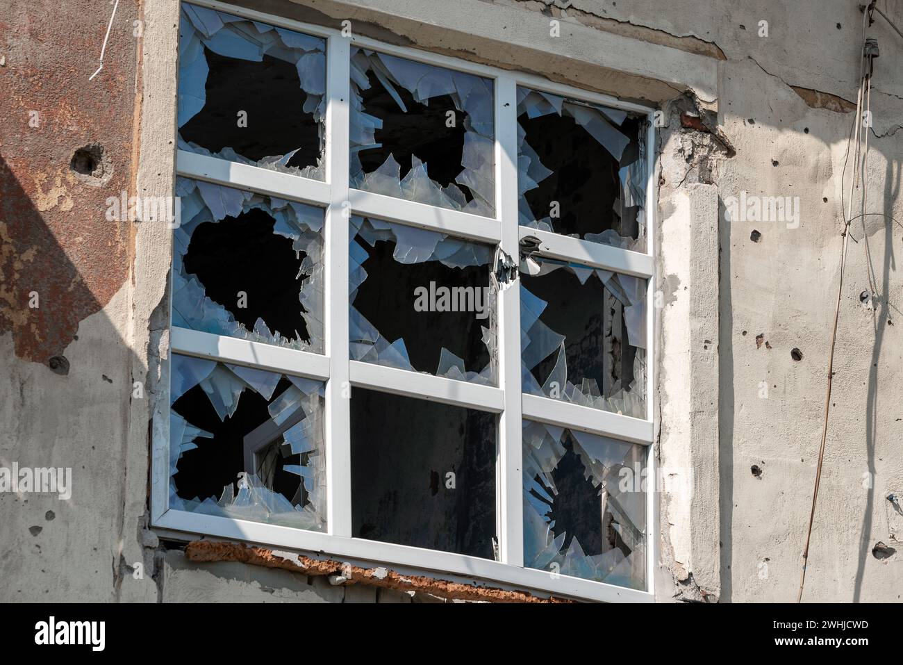 Finestre vuote di una casa danneggiata in Ucraina Foto Stock