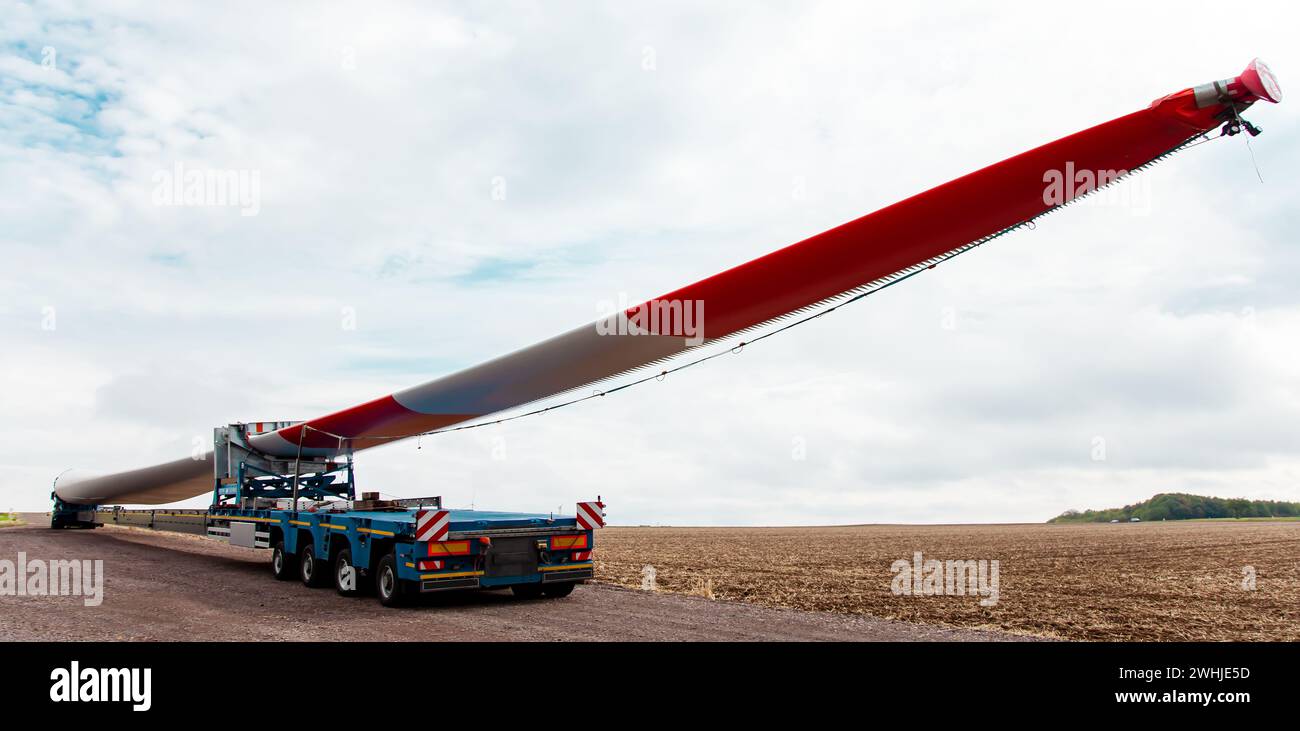 Turbine eoliche in costruzione. Pala per turbine eoliche in primo piano. Trasporto speciale di una lama Foto Stock