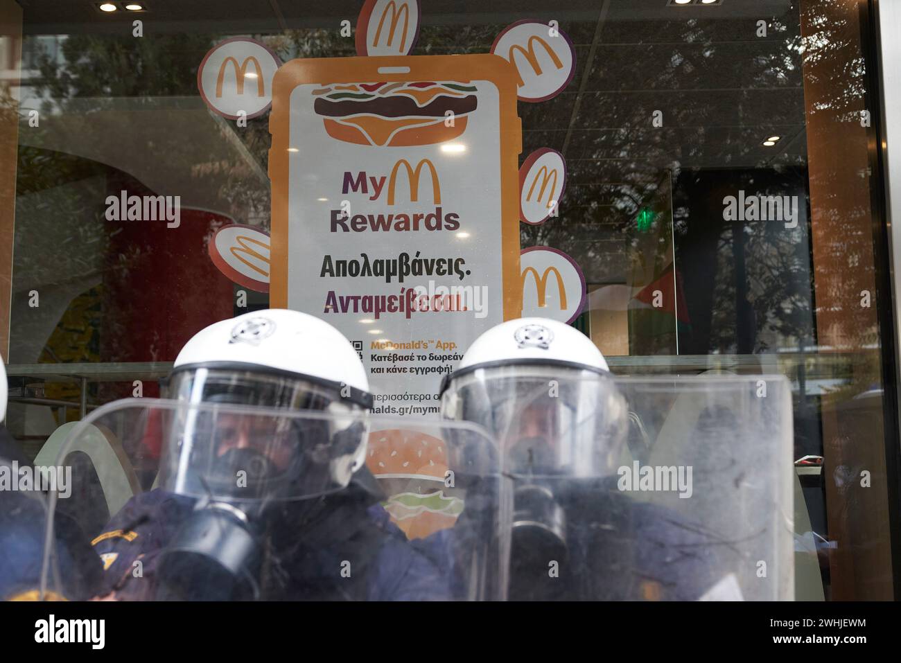 Atene, Grecia. 10 febbraio 2024. La polizia antisommossa protegge l'area intorno al negozio del McDonalds utilizzando gas lacrimogeni e granate flash bang. Mothers Against Genocide ha organizzato una protesta fuori McDonalds nel centro di Atene, sostenendo che la multinazionale sostiene Israele. (Credit Image: © Nikolas Georgiou/ZUMA Press Wire) SOLO PER USO EDITORIALE! Non per USO commerciale! Foto Stock