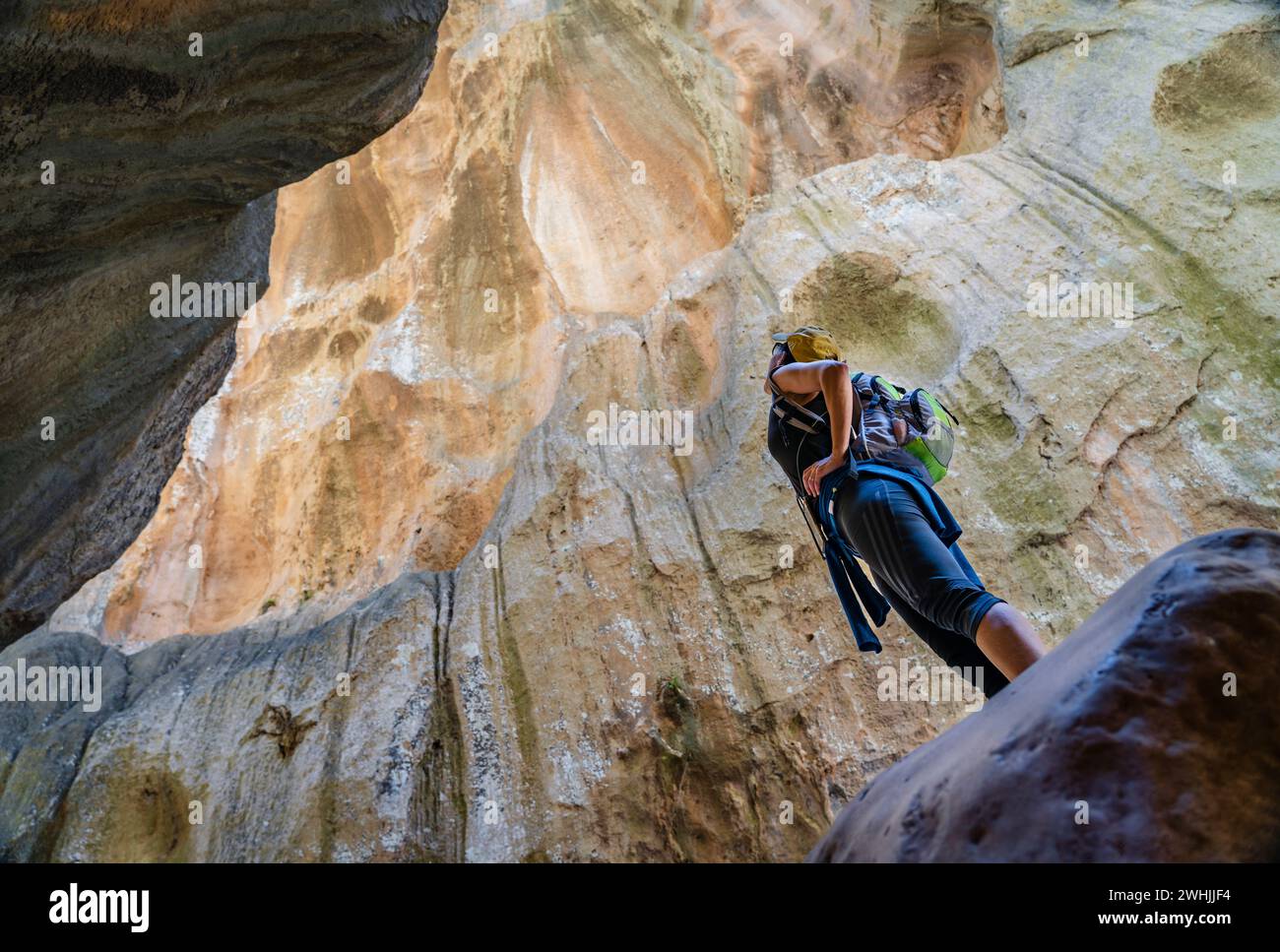 Escursionista ammirando le pareti di roccia verticali Foto Stock