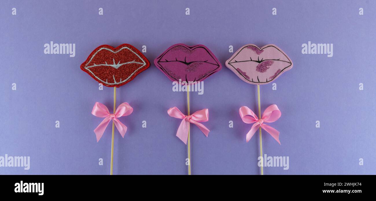 Labbra con il nastro su un bastoncino con sfondo viola Foto Stock