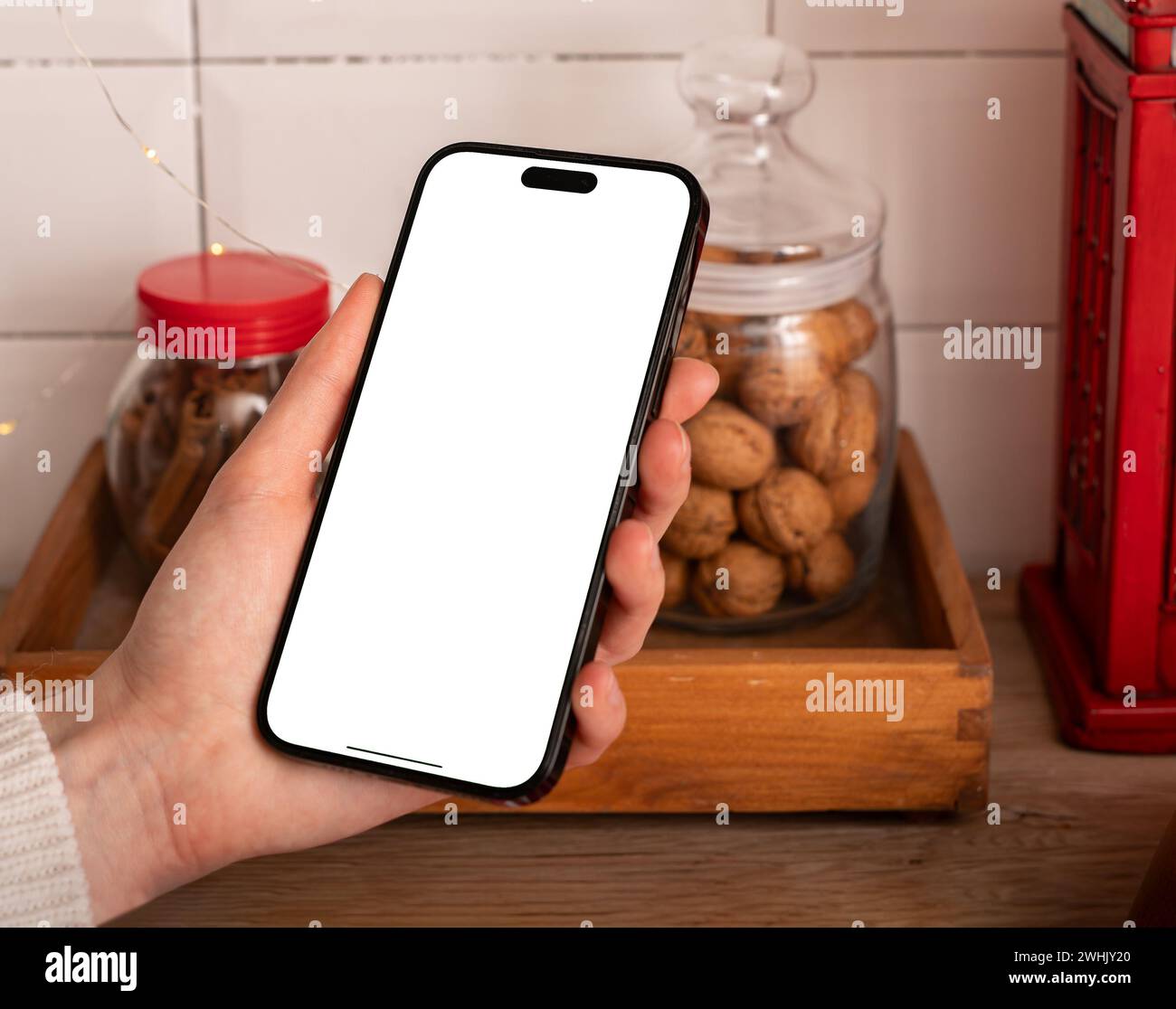 Berlino Germania 21 gennaio 2024 mockup dello schermo iPhone in mano, mock-up del telefono cellulare in cucina Foto Stock
