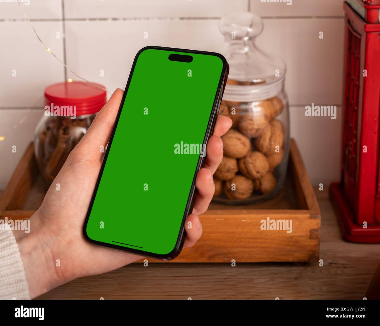 Berlino Germania 21 gennaio 2024 mockup dello schermo iPhone in mano, mock-up del telefono cellulare in cucina Foto Stock