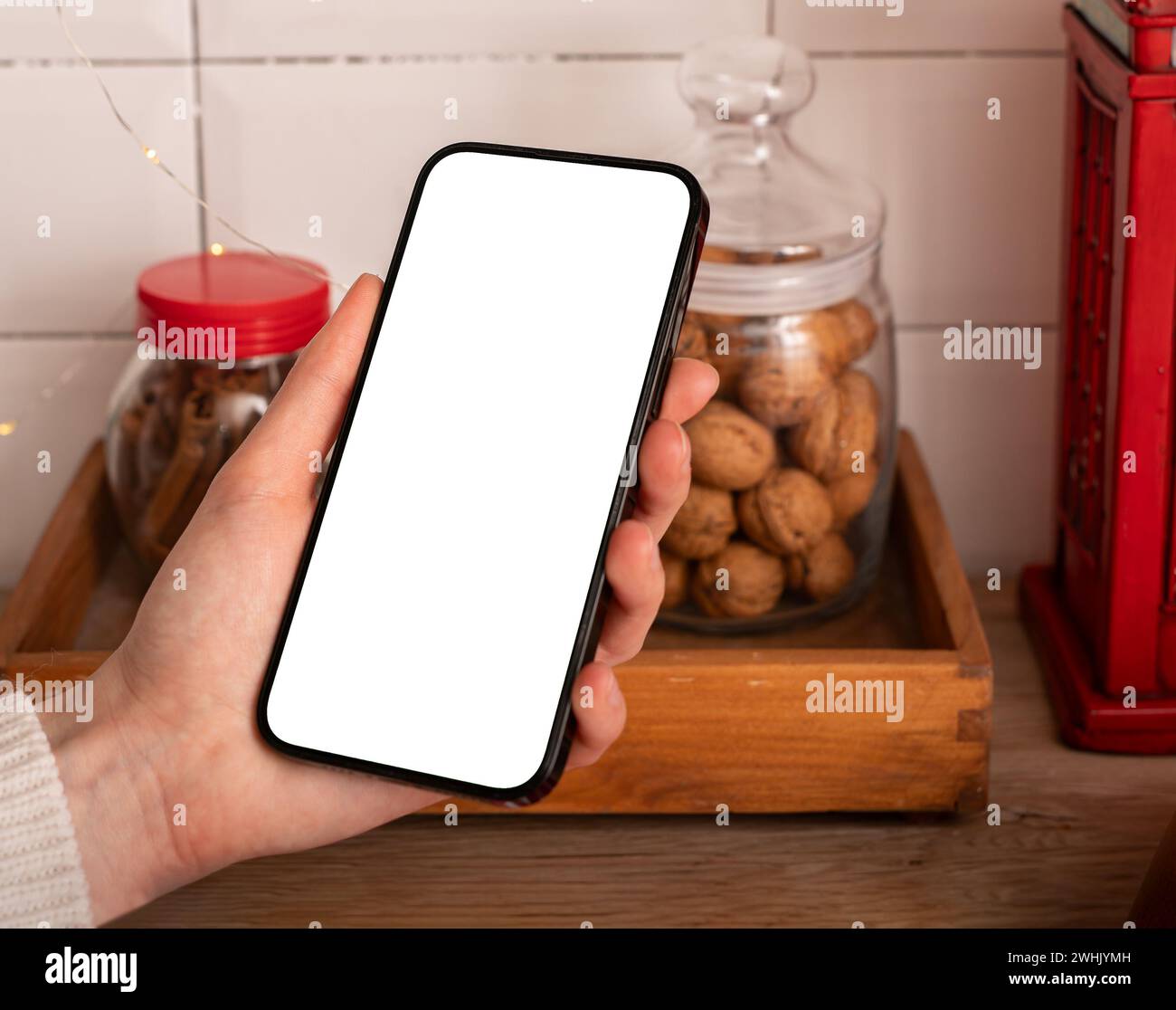 Mockup dello schermo dello smartphone in mano, mock-up del telefono cellulare in cucina, app di cucina Foto Stock
