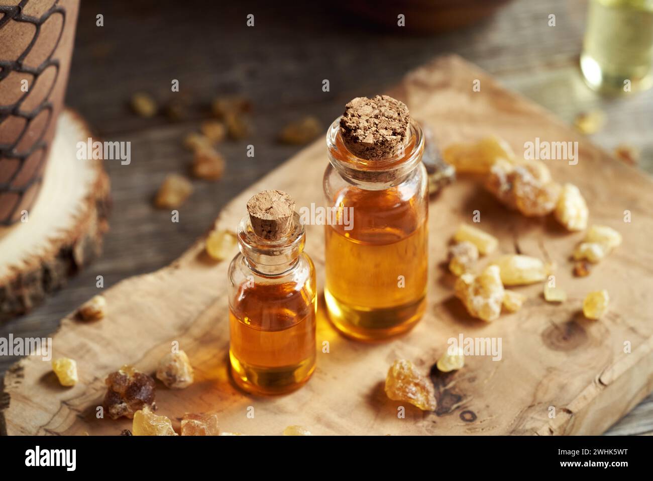 Due bottiglie di olio essenziale di incenso con resina boswellia su un tavolo di legno Foto Stock