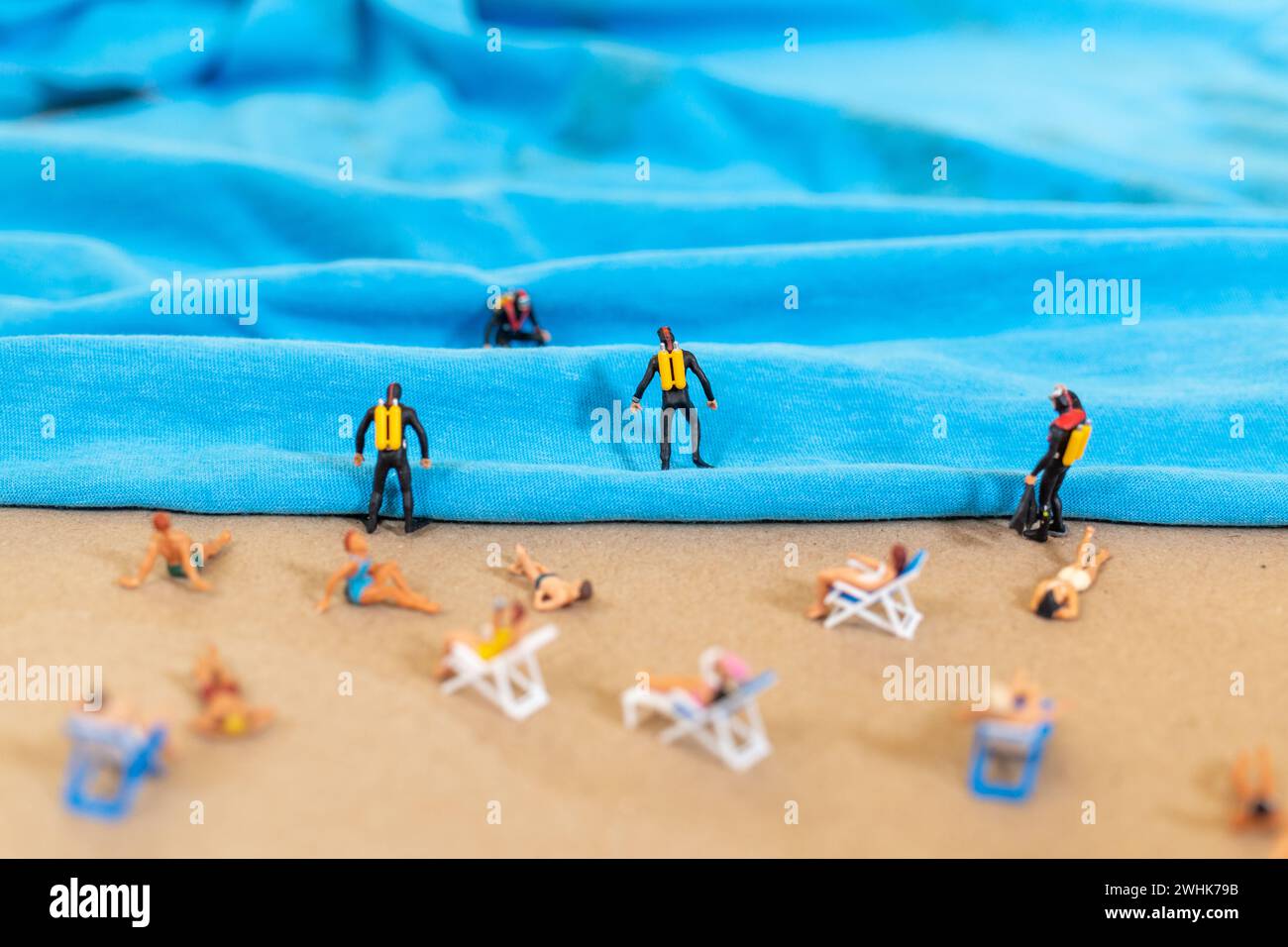 Una piccola persona con una tuta da immersione sulla spiaggia in estate Foto Stock