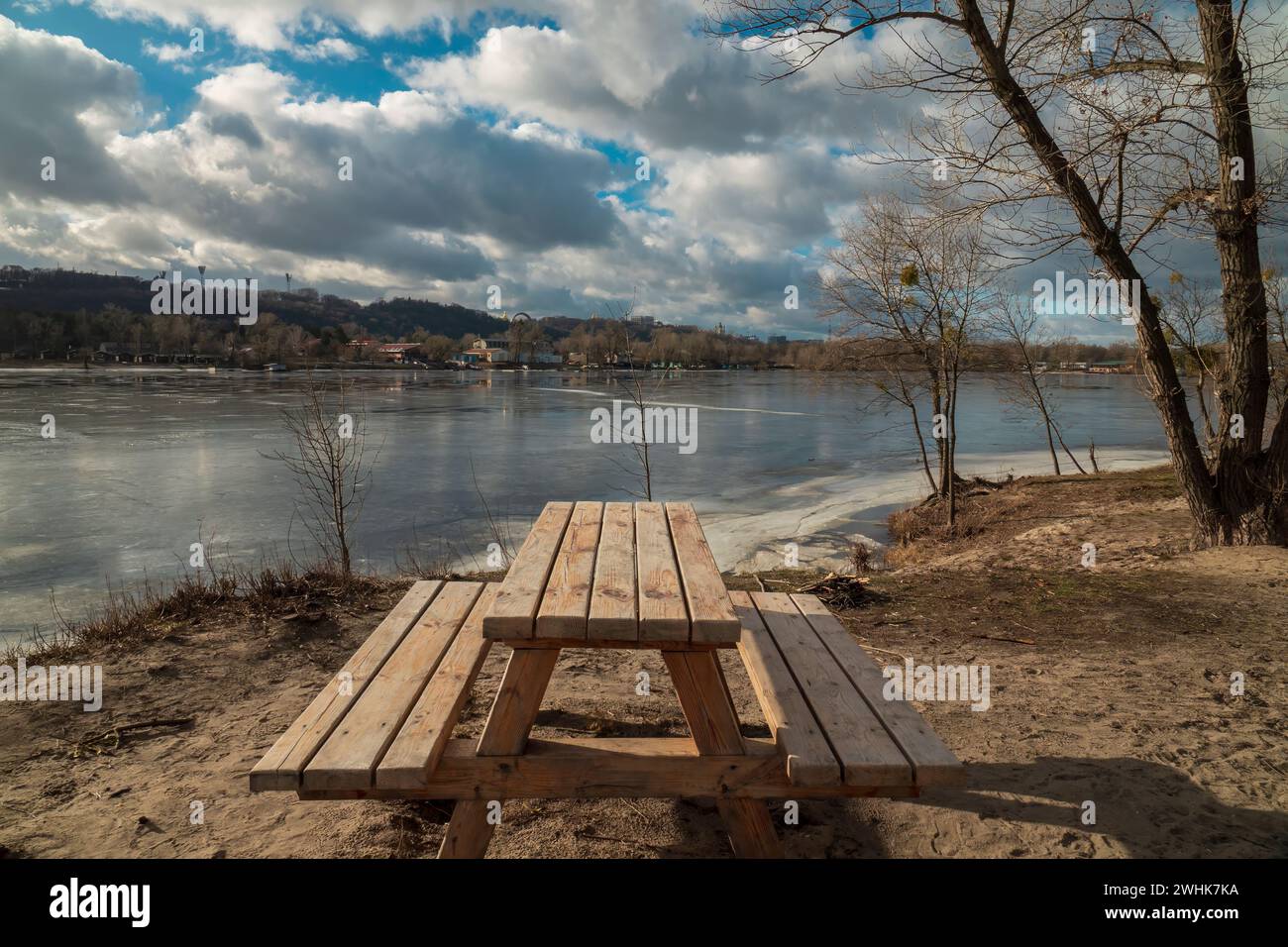 Posto di riposo in legno sulla riva del fiume all'inizio della primavera. Kiev, Ucraina Foto Stock