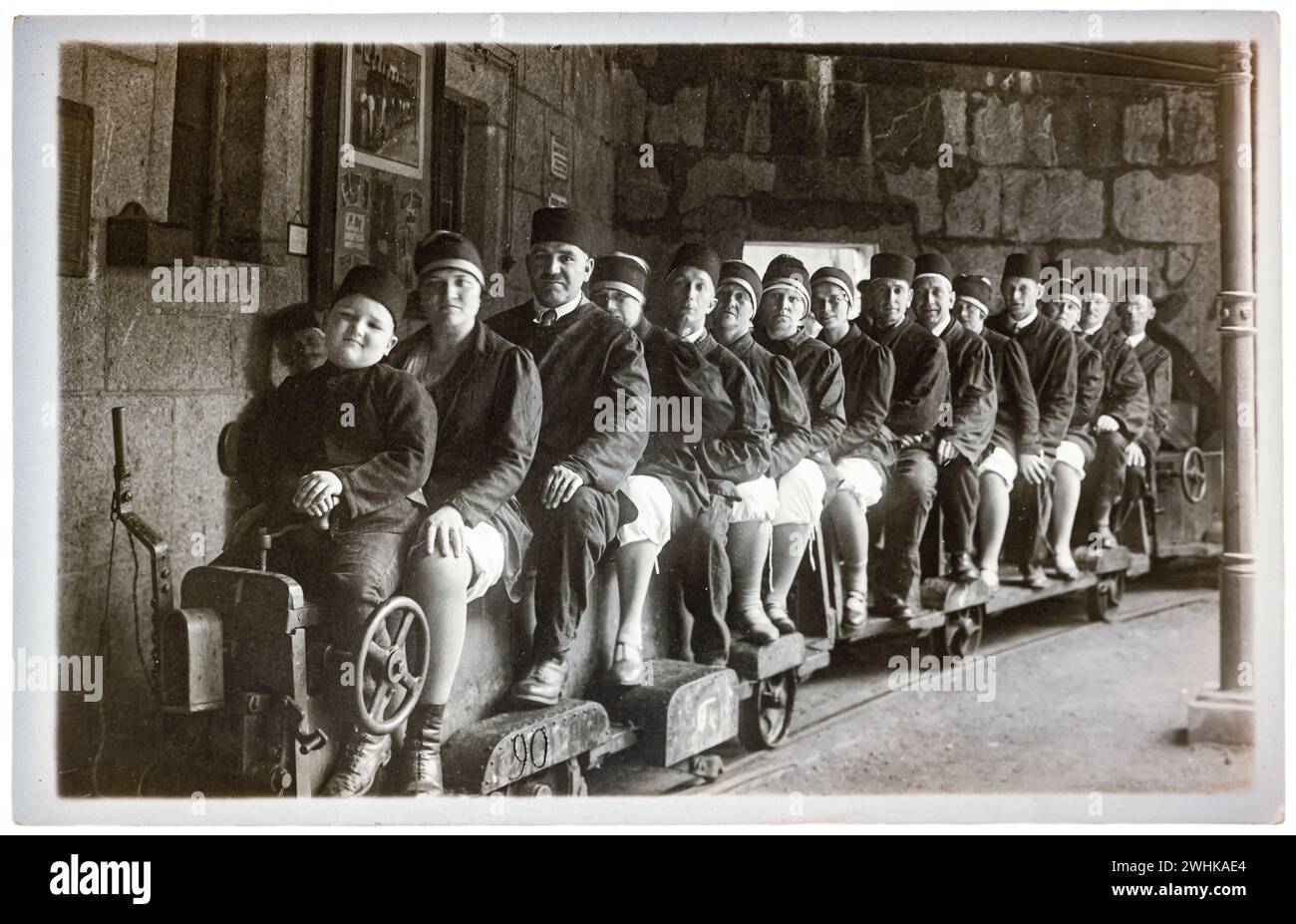 Foto d'epoca nostalgica di persone sedute su un carro per miniere di sale per lavorare sottoterra. Foto Stock