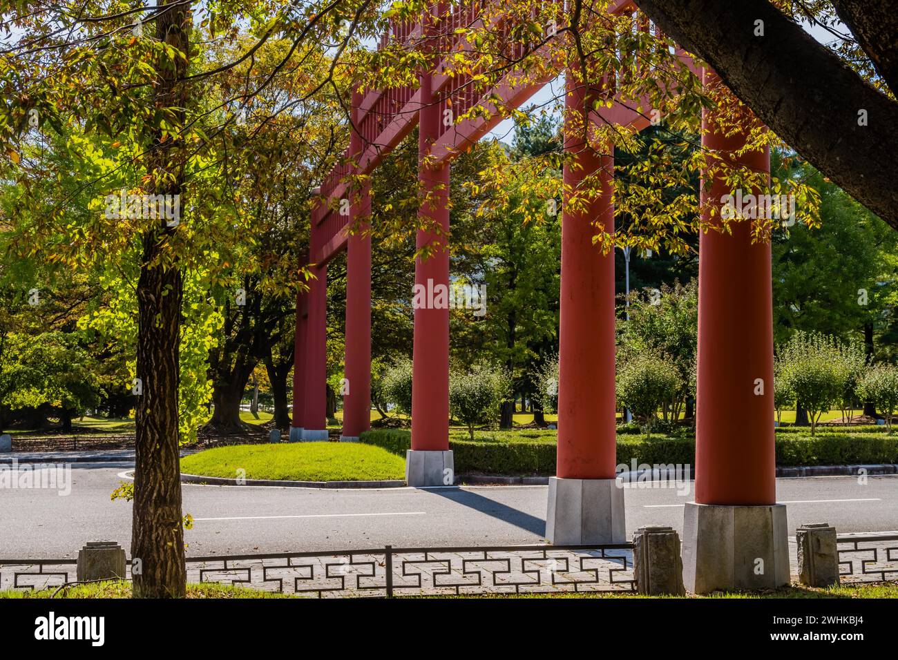 Primo piano di colonne di grande cancello in legno di stile giapponese attraverso la strada a quattro corsie nel parco pubblico della Corea del Sud Foto Stock