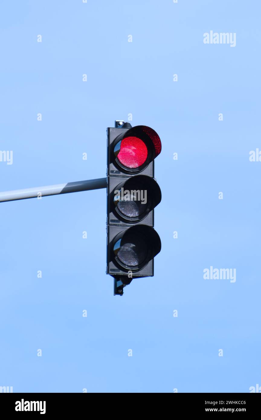 Al semaforo, fermati al semaforo rosso. Isolato su sfondo blu. Spazio di copia negativo. Giornata di sole. Foto Stock