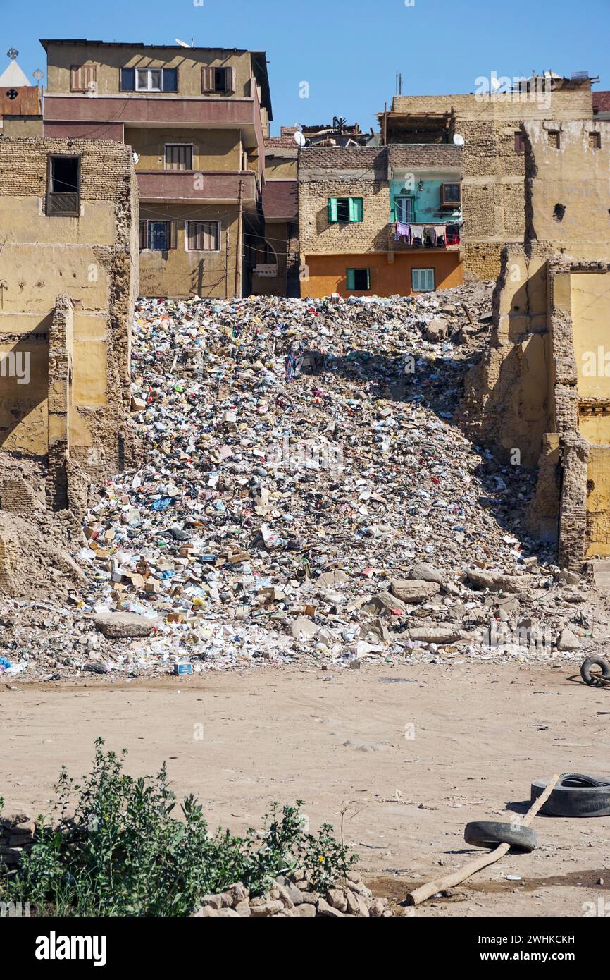 Un mucchio di spazzatura mescolato con detriti, tra vecchie case in una zona residenziale povera di Assuan, Egitto. Foto Stock