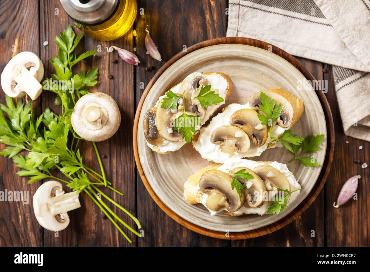 Bruschetta fatta in casa con funghi. Panino tostato con baguette di pane con formaggio morbido e funghi grigliati su rusti di legno Foto Stock