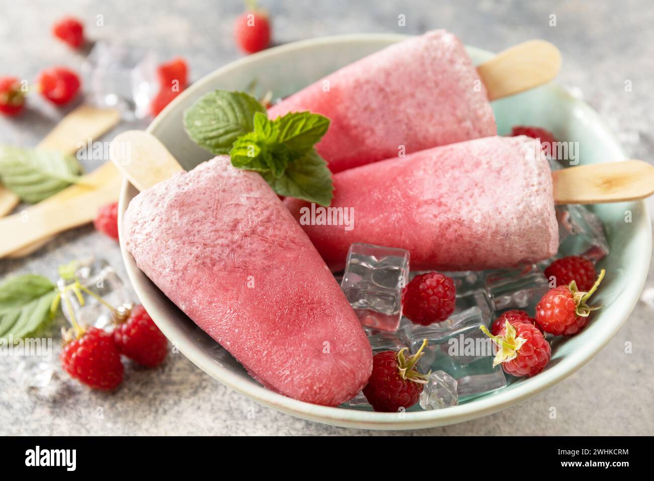 Gelato. Dessert estivo. Papaveri di lampone fatti in casa con yogurt e lamponi su sfondo grigio. Foto Stock