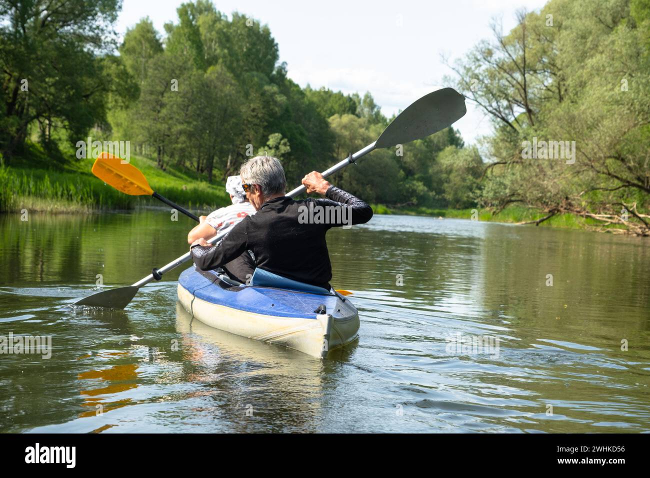 Gita in kayak per tutta la famiglia per il Seigneur e senora. Una coppia di anziani sposati che voga una barca sul fiume, un'escursione in acqua, un avventuriero estivo Foto Stock