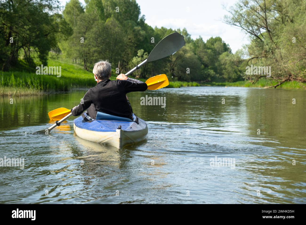 Gita in kayak per tutta la famiglia per il Seigneur e senora. Una coppia di anziani sposati che voga una barca sul fiume, un'escursione in acqua, un avventuriero estivo Foto Stock