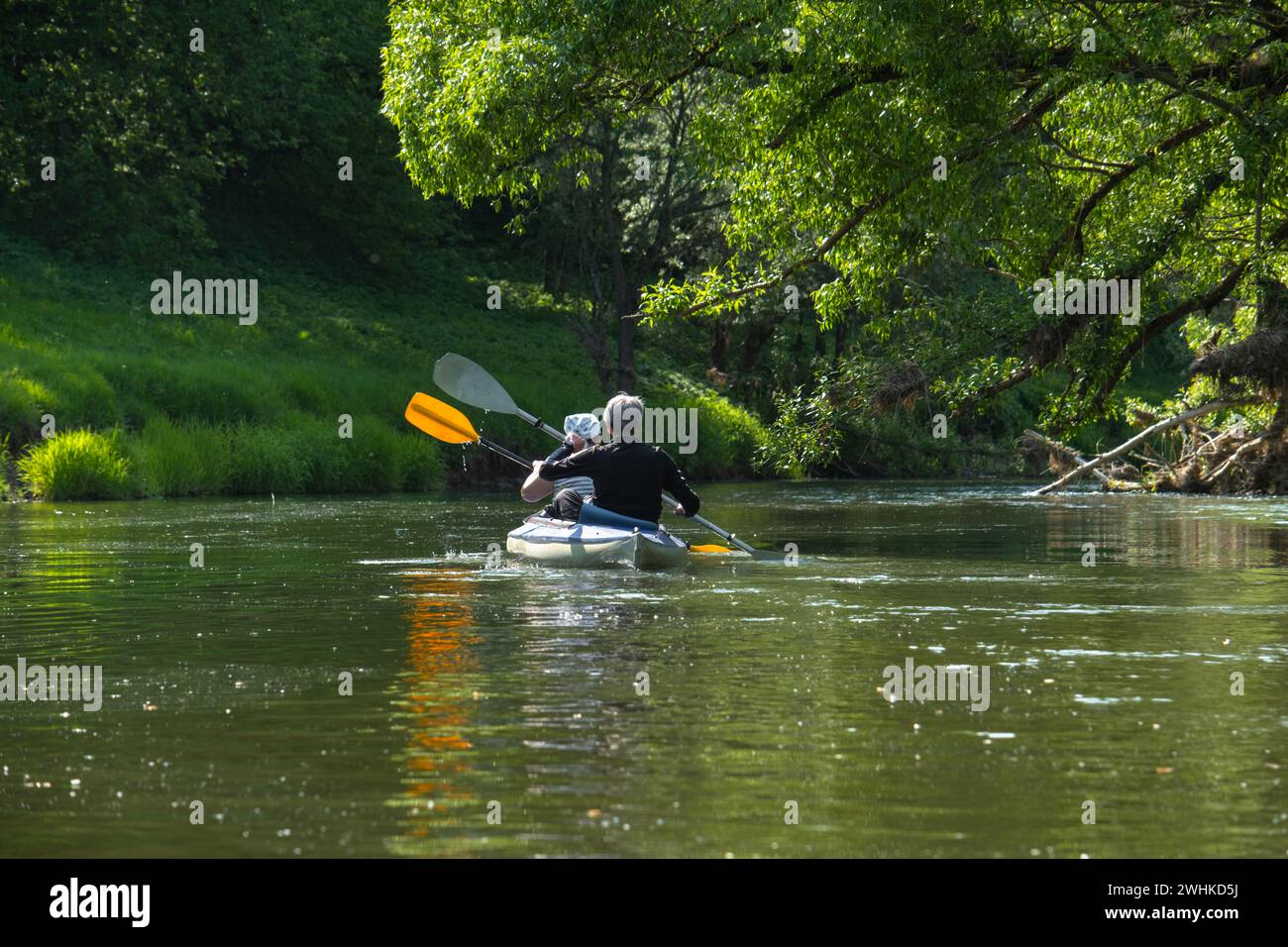 Gita in kayak per tutta la famiglia per il Seigneur e senora. Una coppia di anziani sposati che voga una barca sul fiume, un'escursione in acqua, un avventuriero estivo Foto Stock