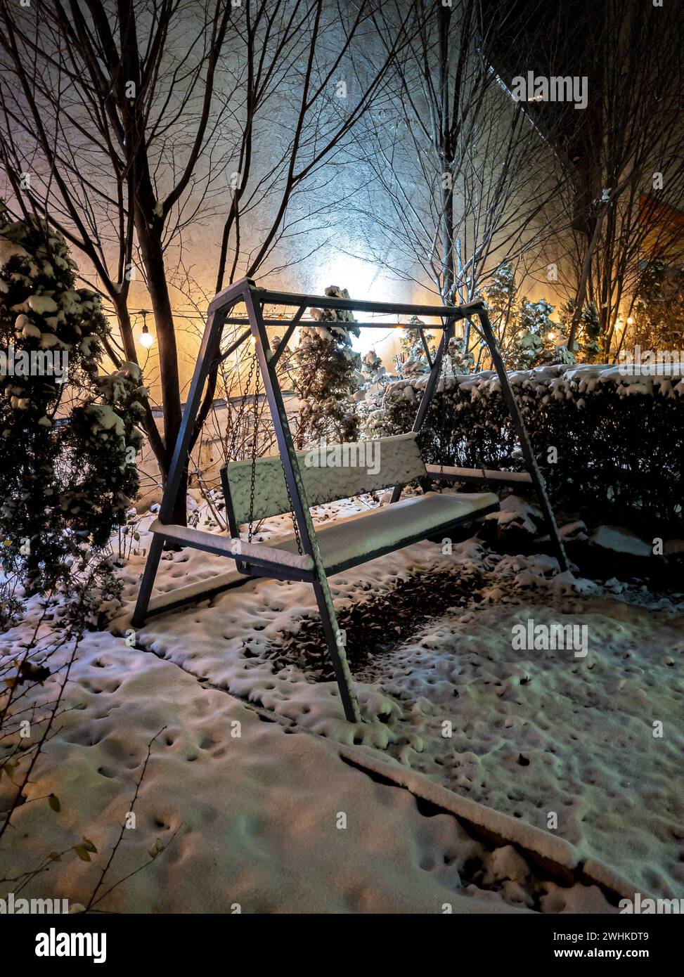 Spesso panca in legno ricoperta di neve nel giardino della caffe Foto Stock