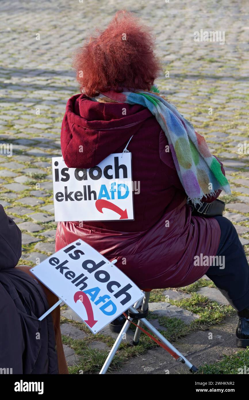 Manifestante seduto sulla sedia pieghevole, striscione con testo AfD è disgustoso, grande manifestazione contro l'estremismo di destra il 27 gennaio 2024 a Foto Stock