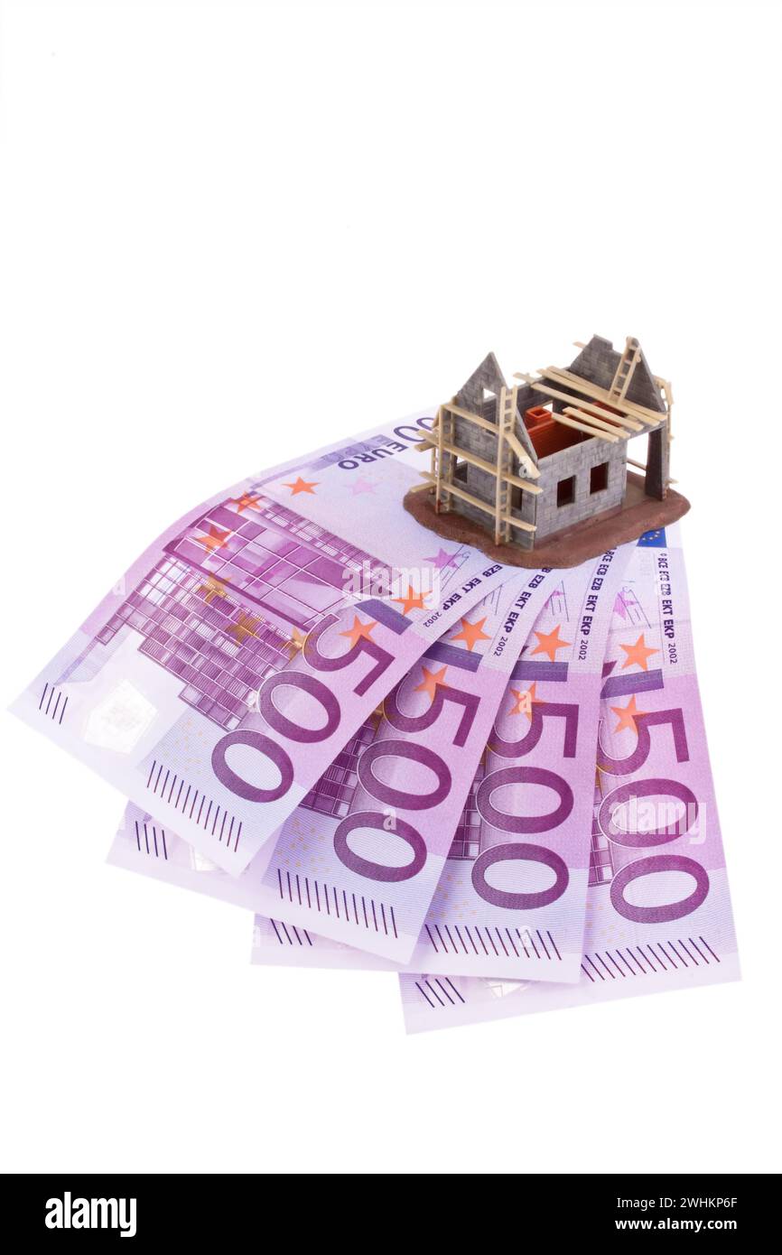 Molte banconote in euro e il guscio di una casa, costi di costruzione, pianificazione Foto Stock