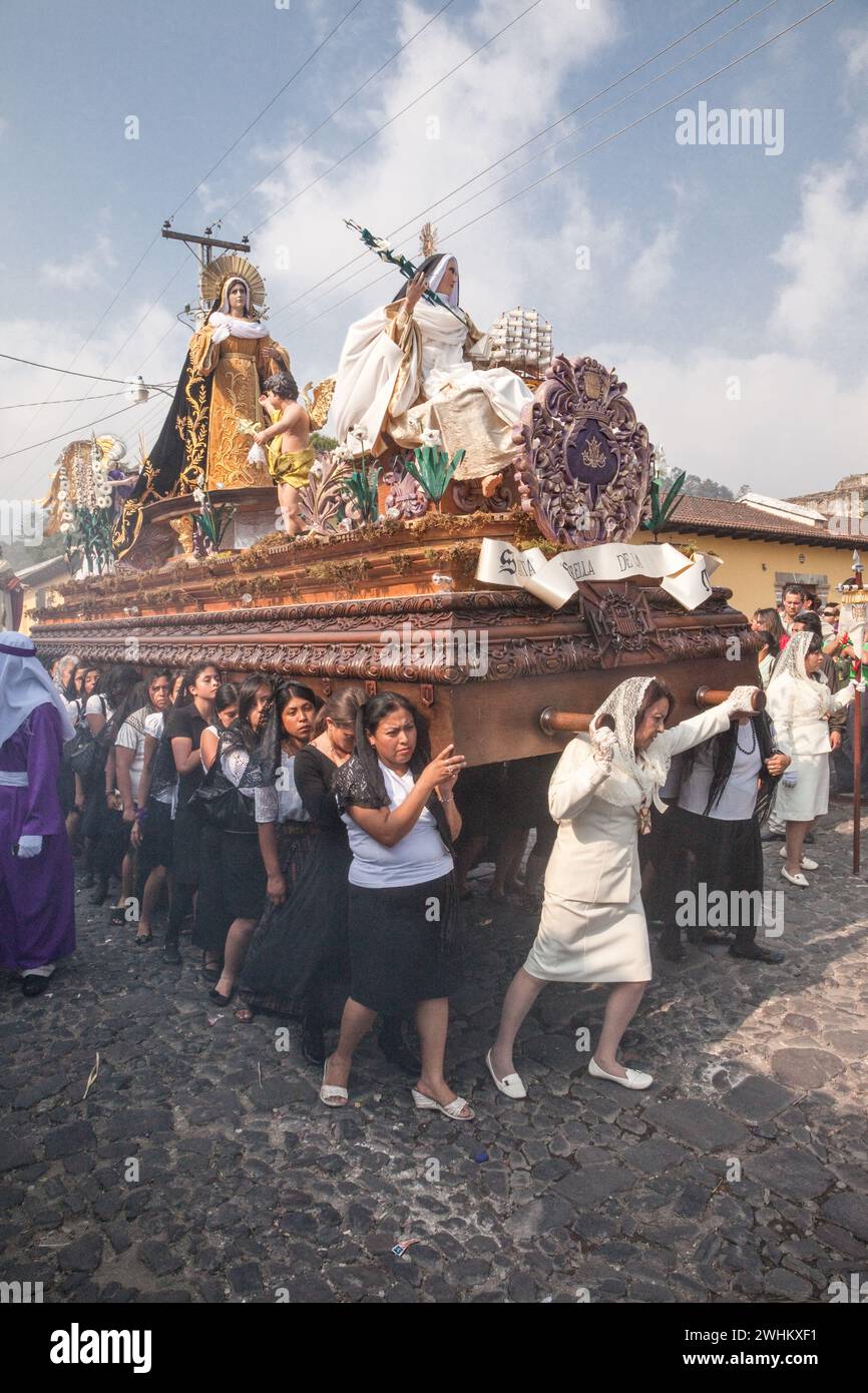 Antigua, Guatemala. Semana Santa (settimana Santa). Donne che portano un Anda (galleggiante) con la Vergine Maria in una Processione religiosa. Foto Stock