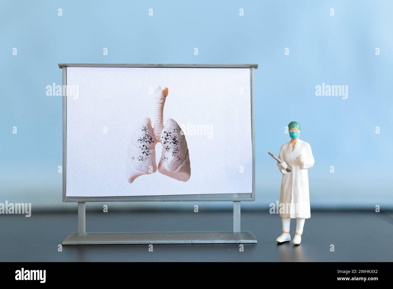 Persone in miniatura. Un medico esamina la polmonite nel quadro, una malattia respiratoria. Foto Stock