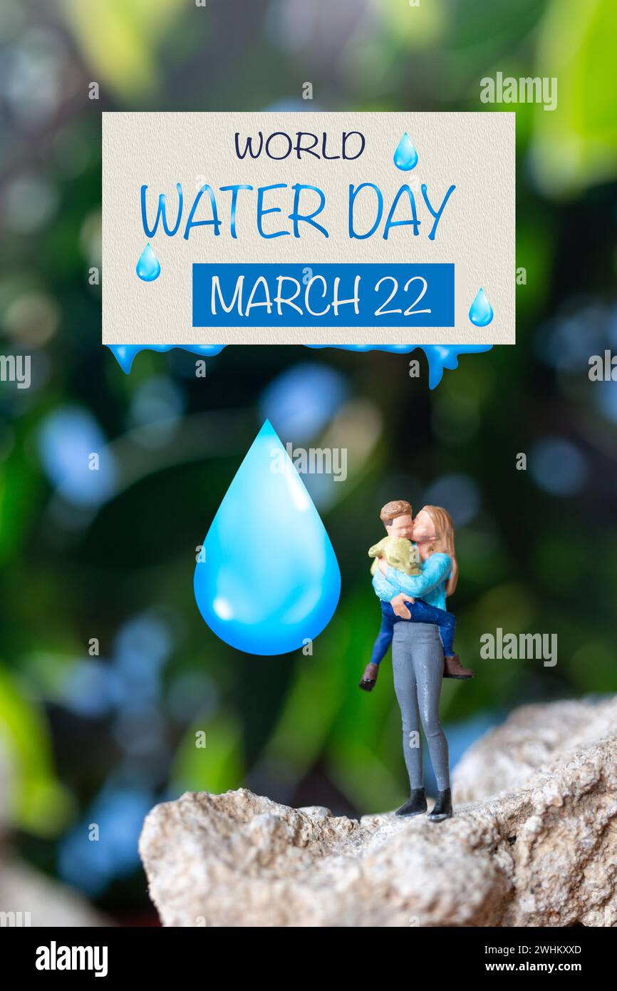 Persone in miniatura madre che tiene il figlio tra le braccia e parole scritte sulla carta giornata Mondiale dell'acqua Foto Stock